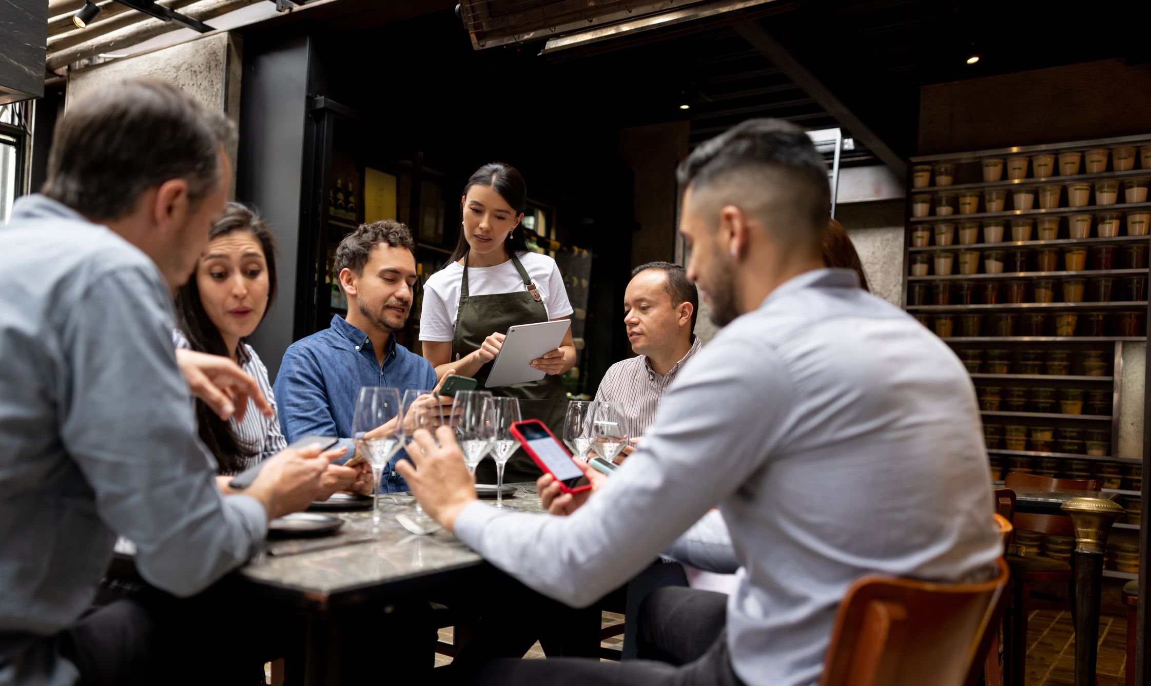 Latin American man at a restaurant asking a question to the waitress about the menu - food service concepts