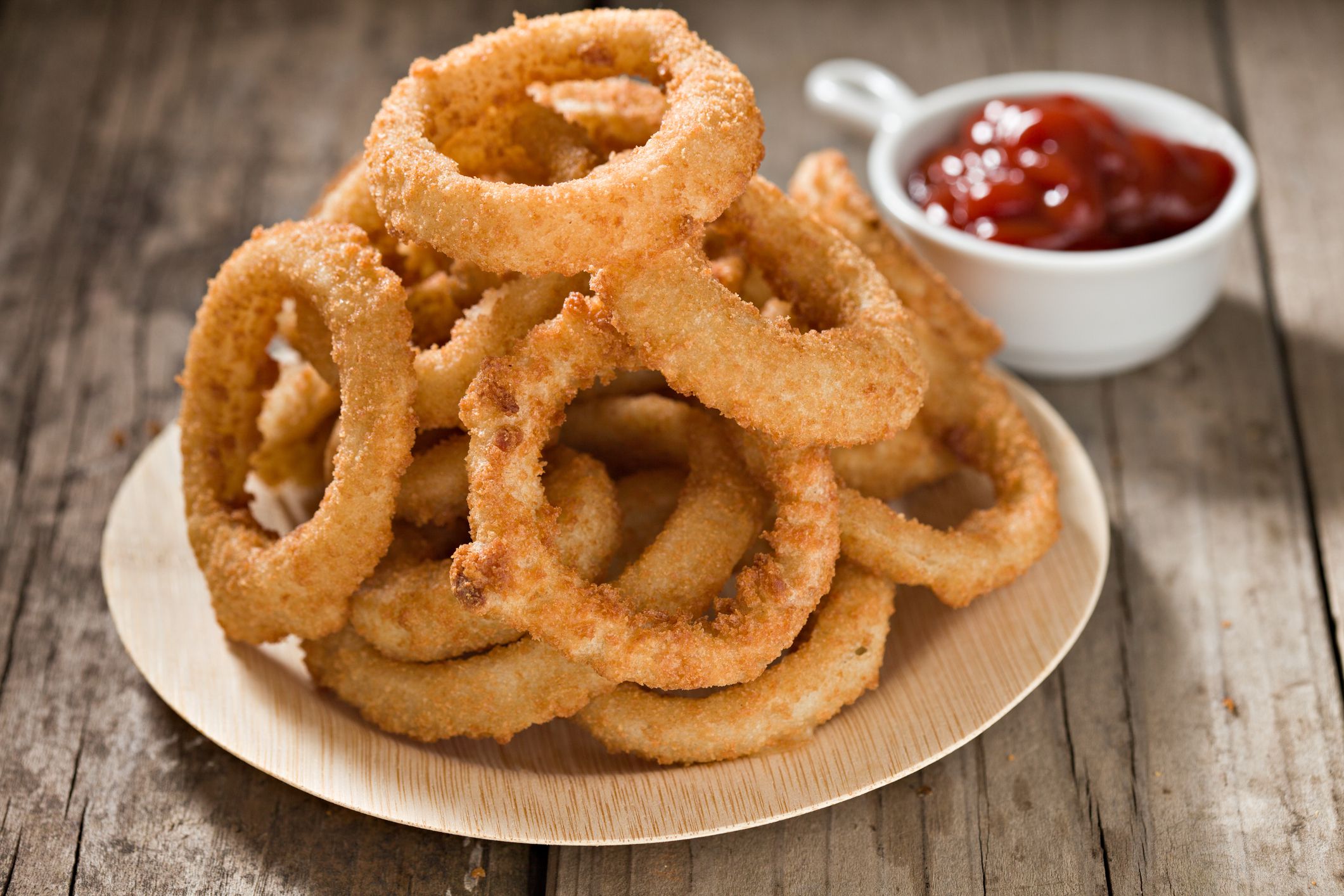 A high angle close up shot of a pile of Onion Rings stacked on a