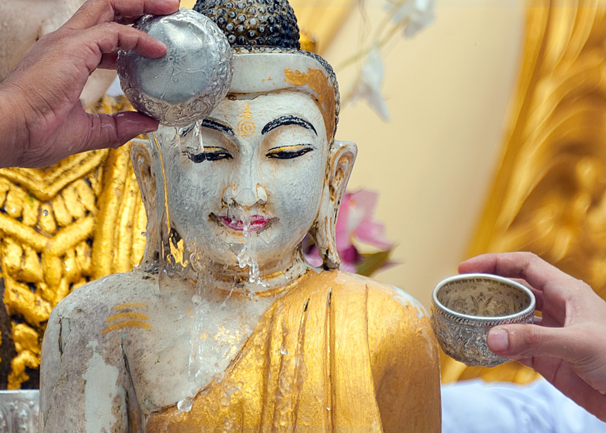 water being poured on statue of buddha