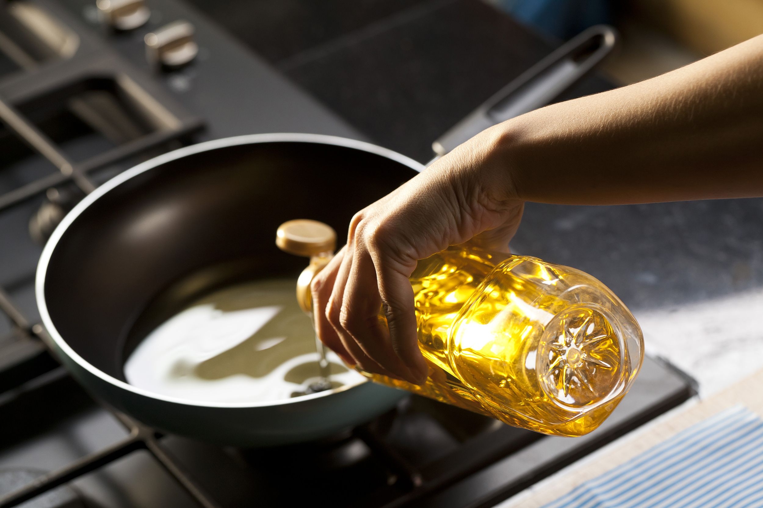 pouring eating oil in frying pan