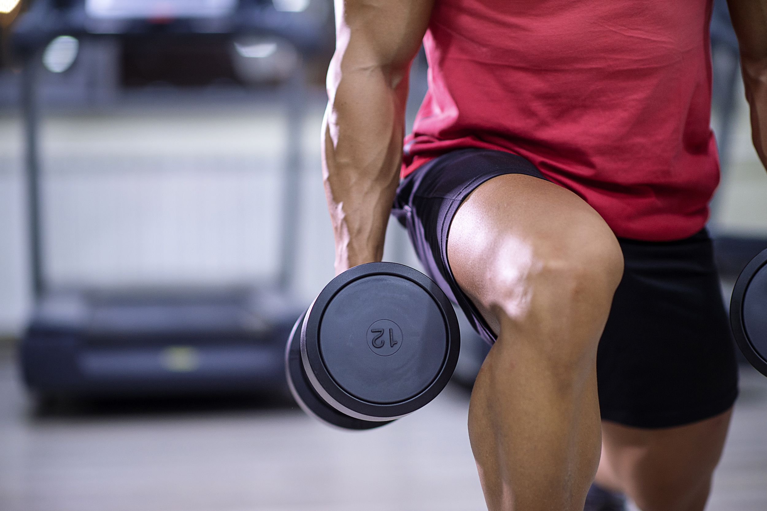 Closeup of man doing lunges with a weight