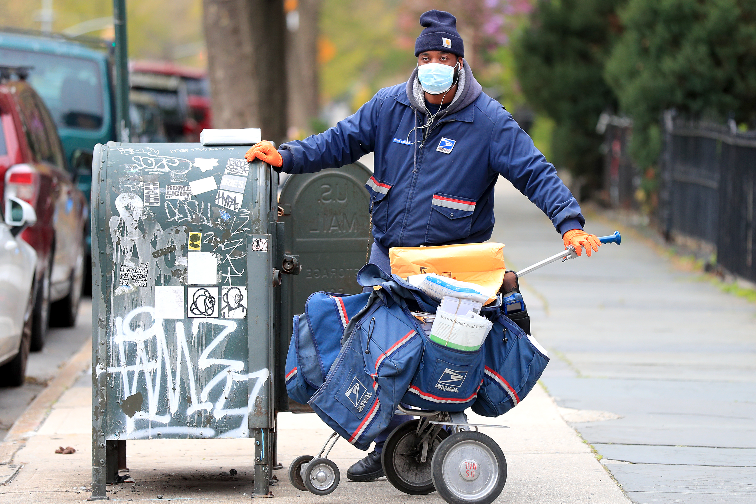 Postal Service worker delivers mail wearing a mask