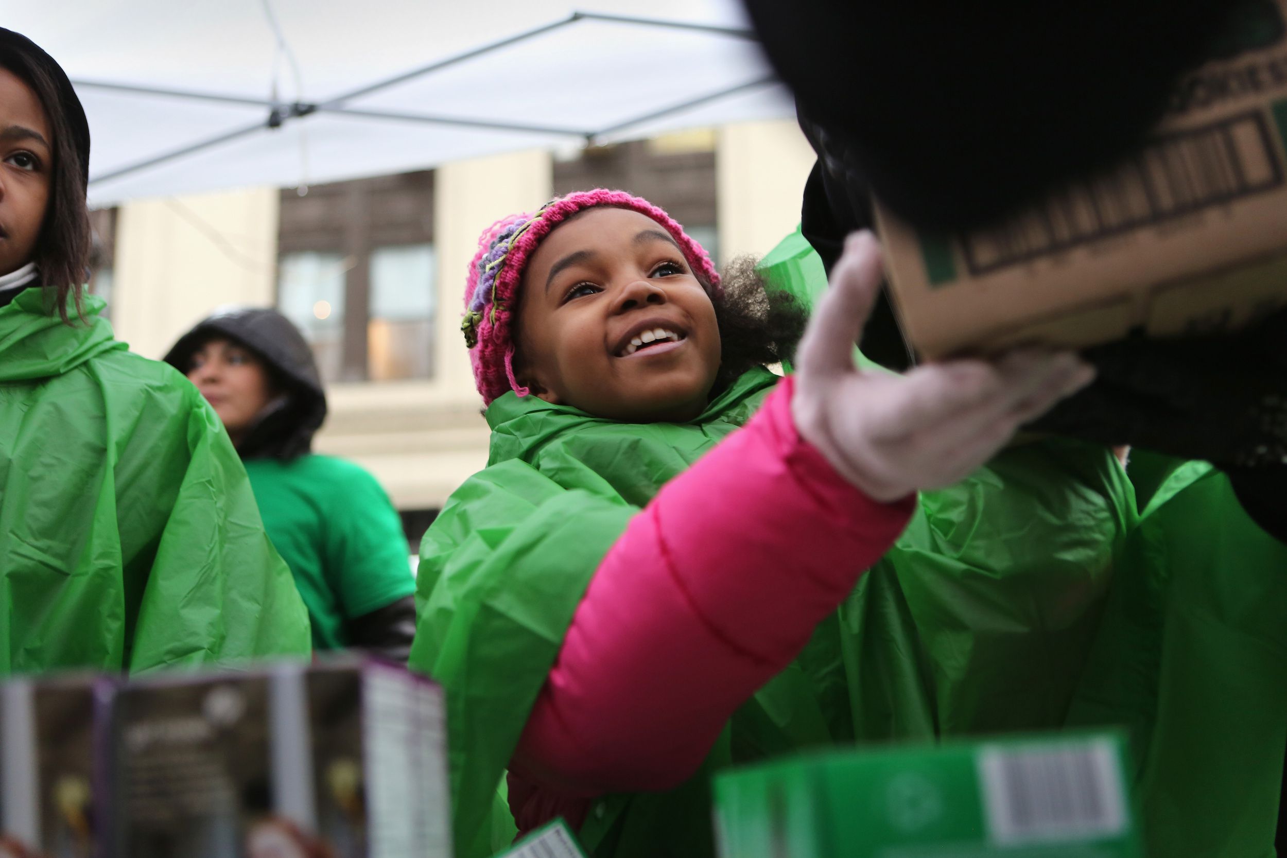 Little Girl Scout Smiling as She Gives Boxes of Girl Scout Cookies to Customer