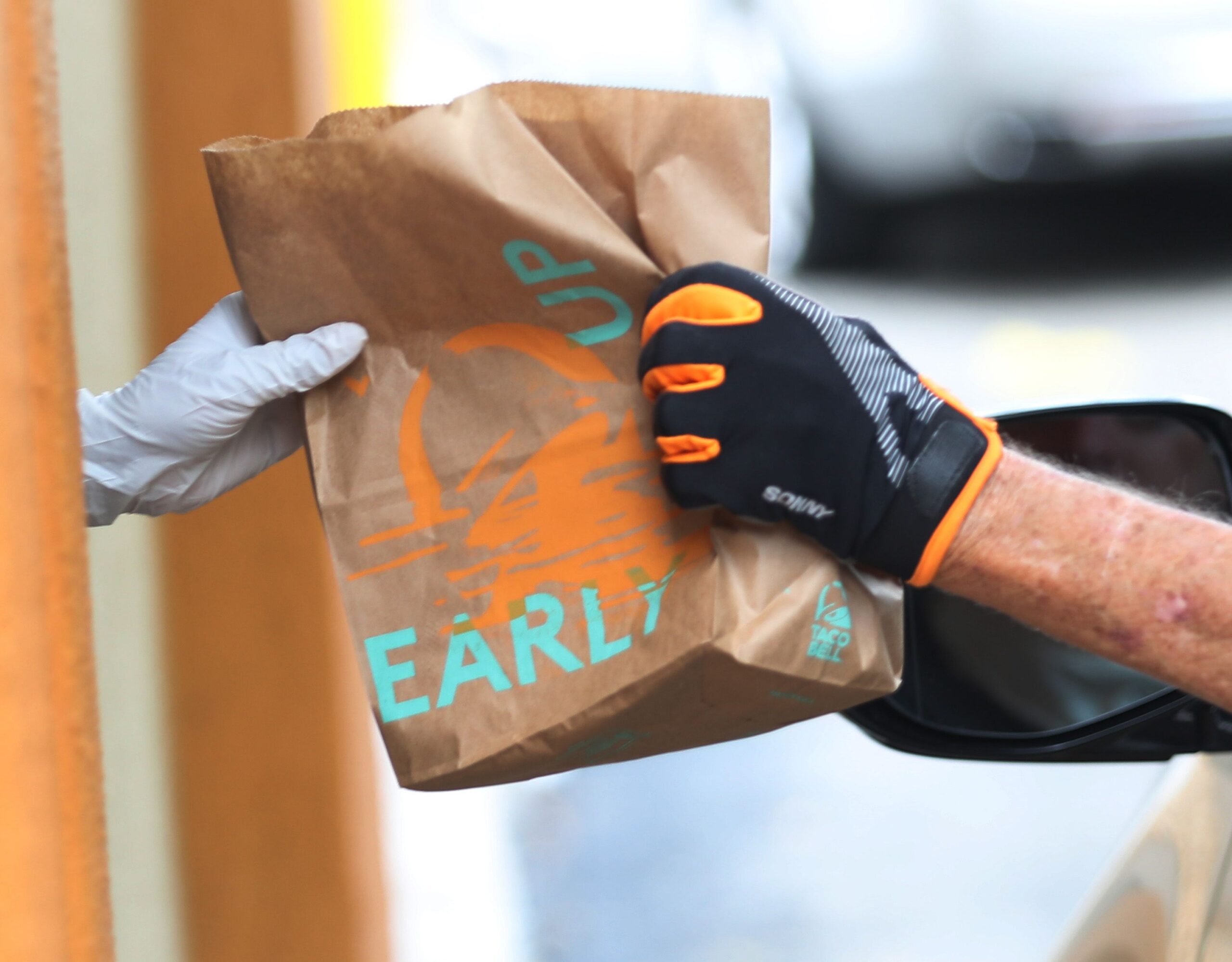 Employee Delivers an Order to a Customer in a Car at the Taco Bell Drive-Up Window, Hollywood, Florida