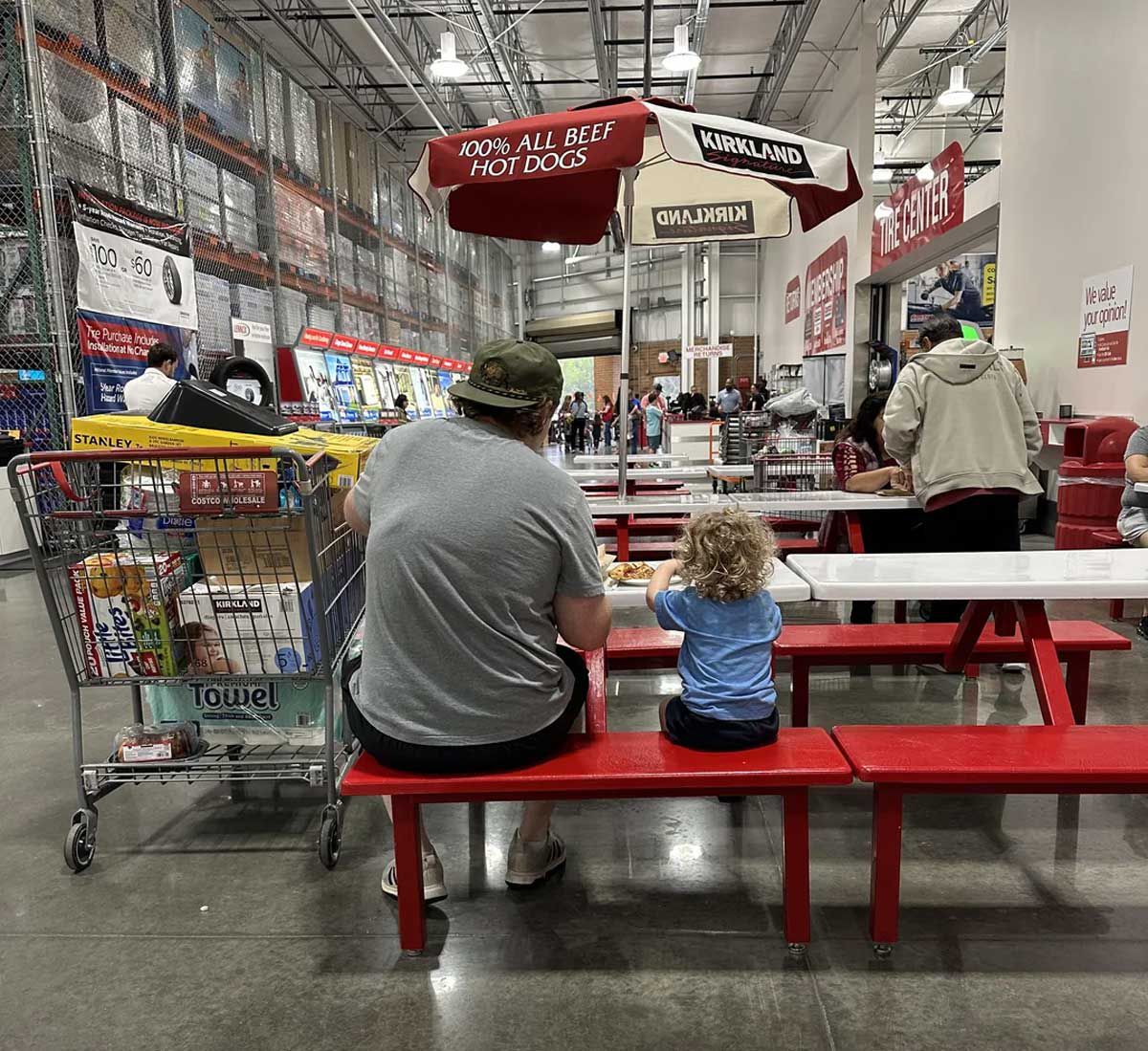 Father and son sitting in the costco food court