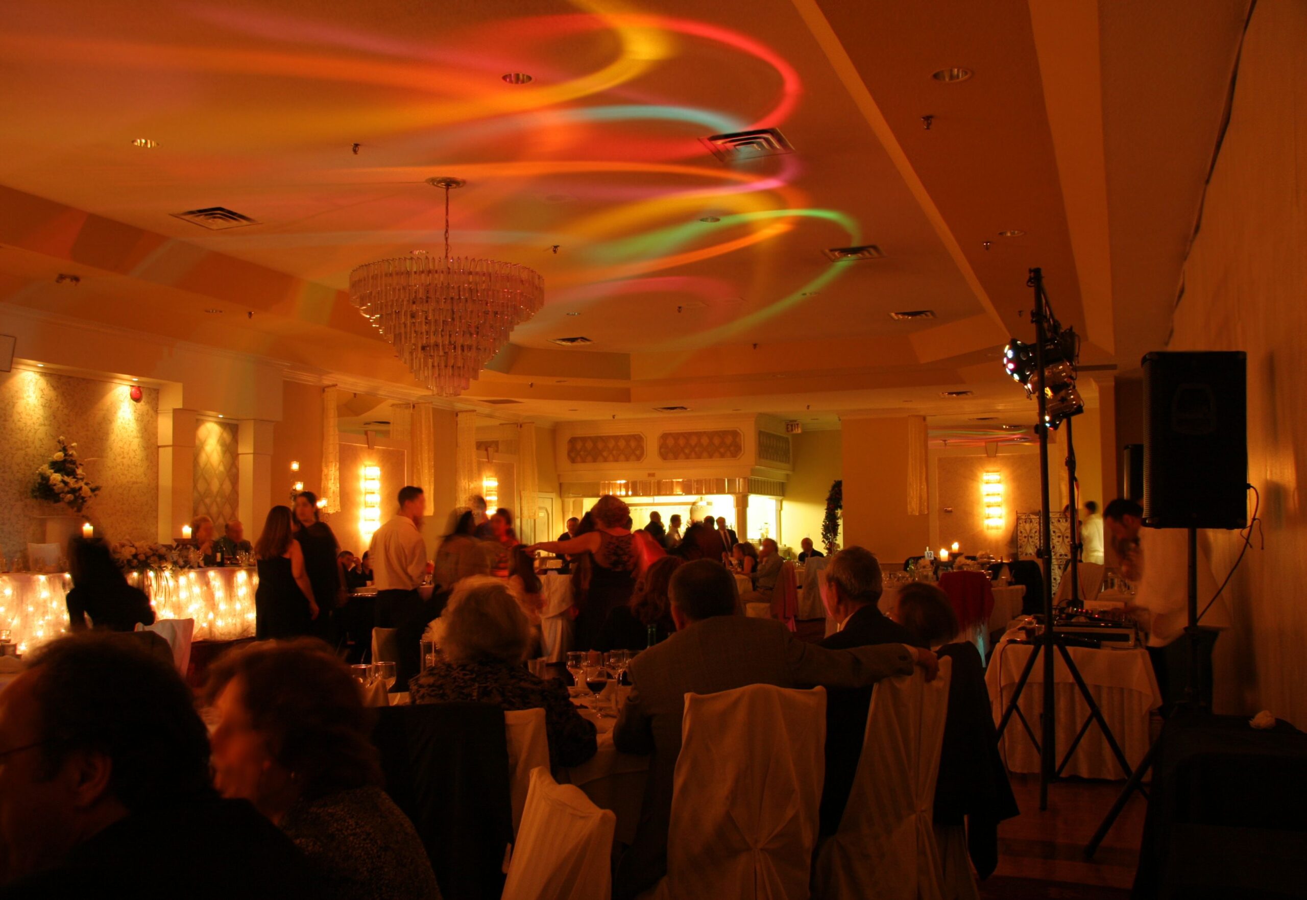 This is a picture taken at a wedding party. The lights are dimmed and the DJ is doing is thing with strobes on the sealing and everyone is happy.