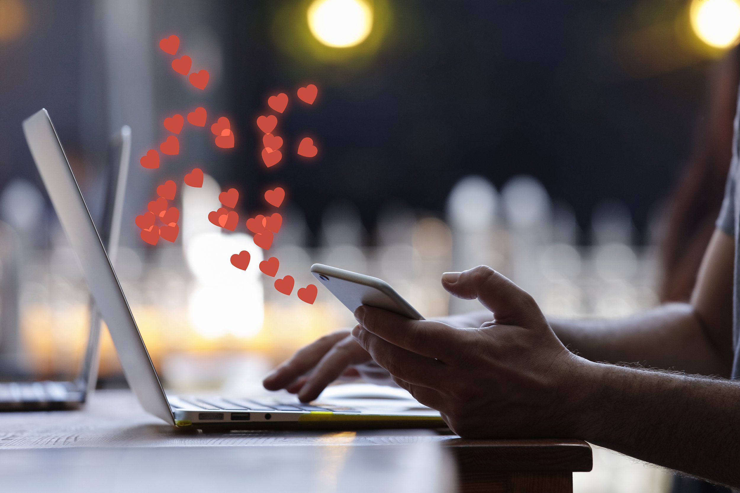 person on both laptop and phone with hearts coming out