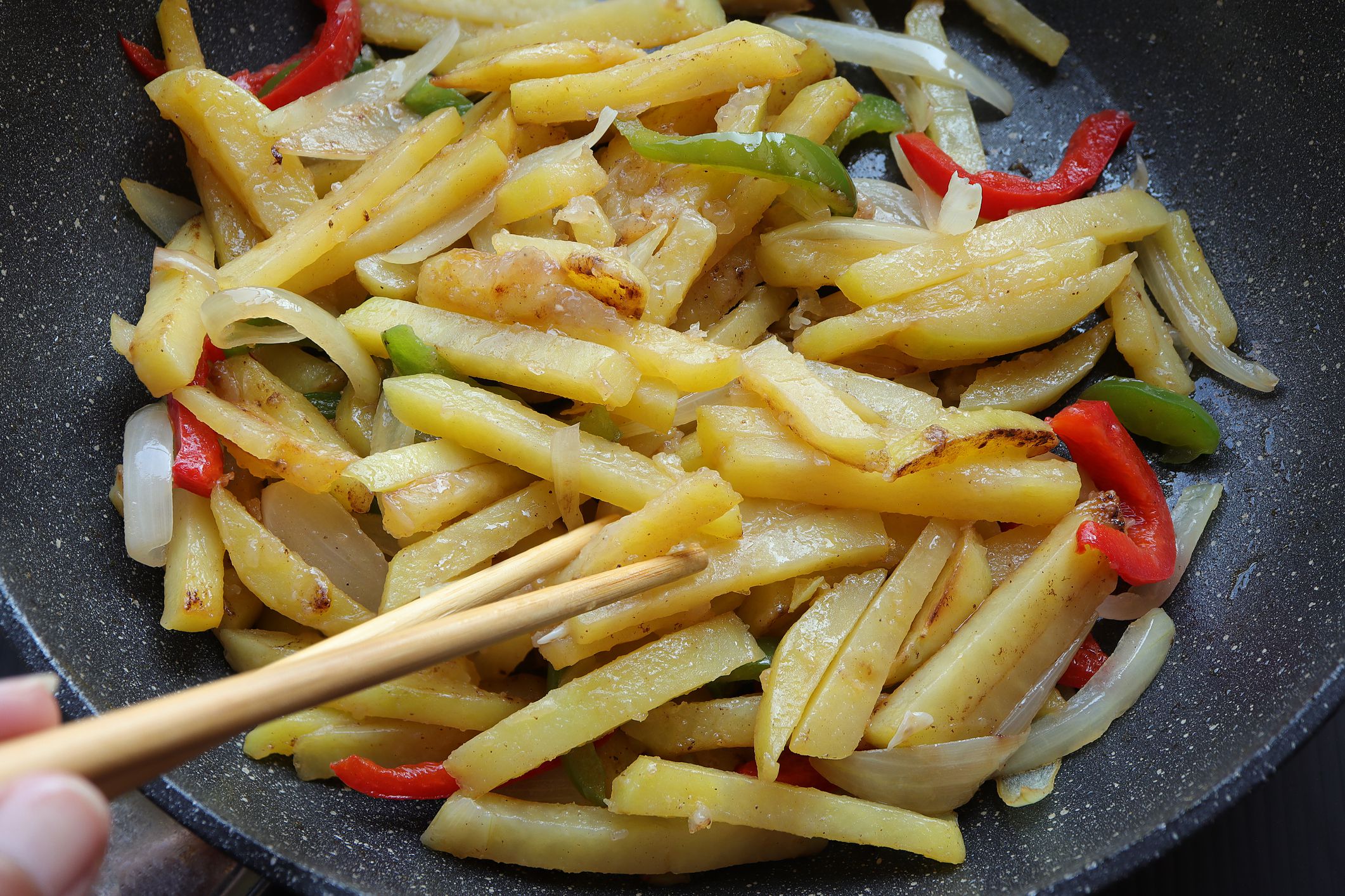 Closeup of Sichuan Stir-Fried Potato Slivers Cooking in a Skillet
