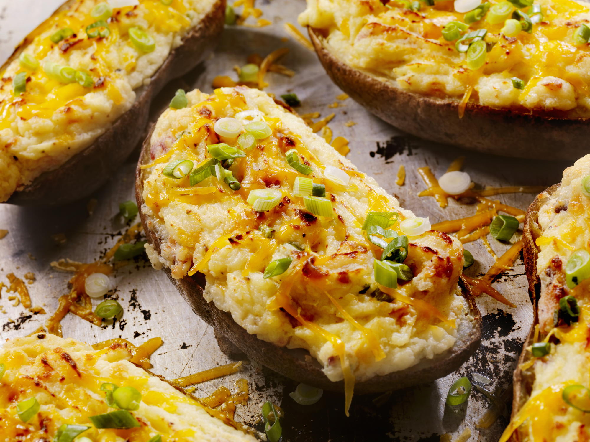Closeup of Twice Baked Potatoes With Cheese and Bacon on Baking Pan