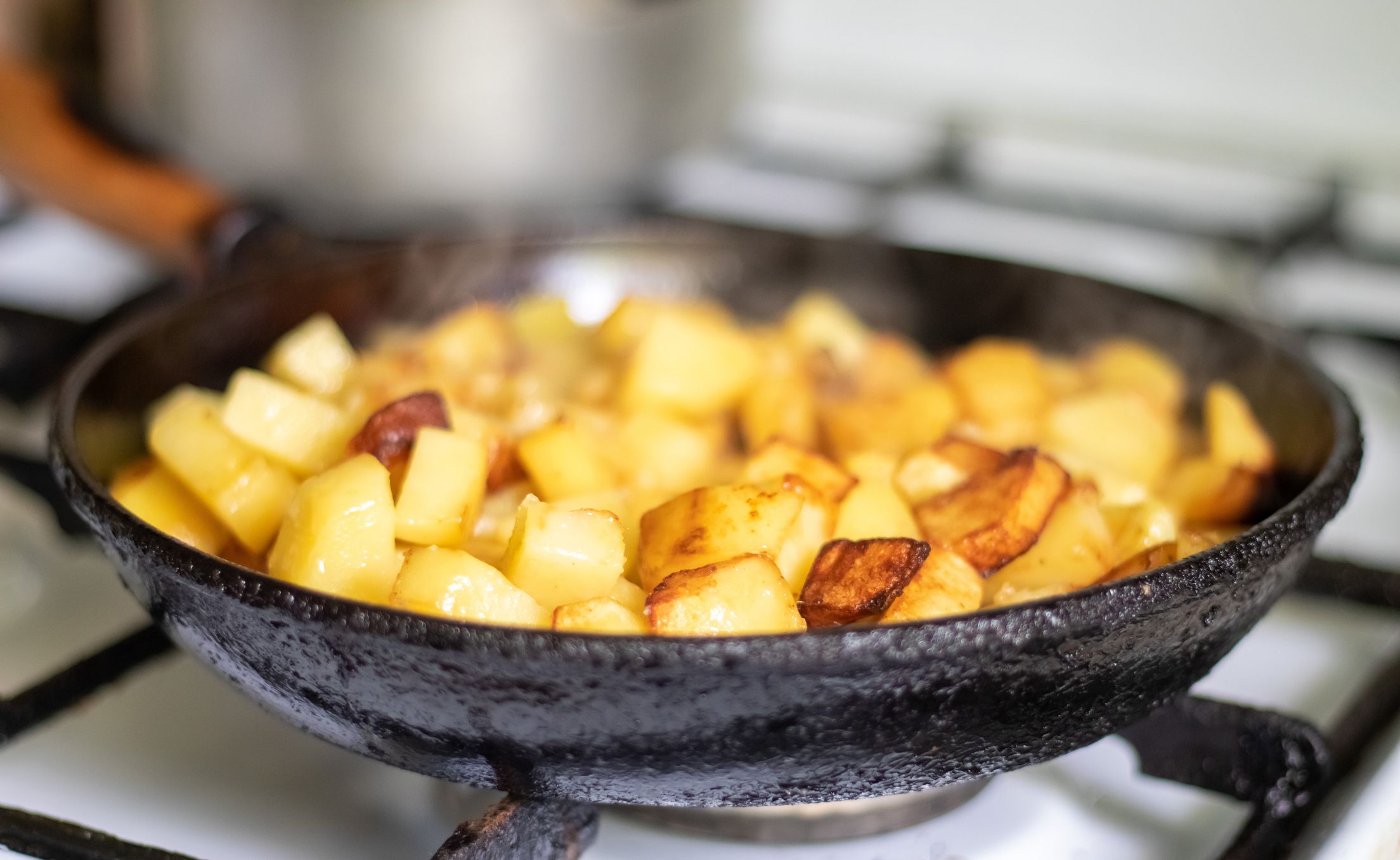 Diced Breakfast Potatoes Being Fried on a Skillet on the Stove