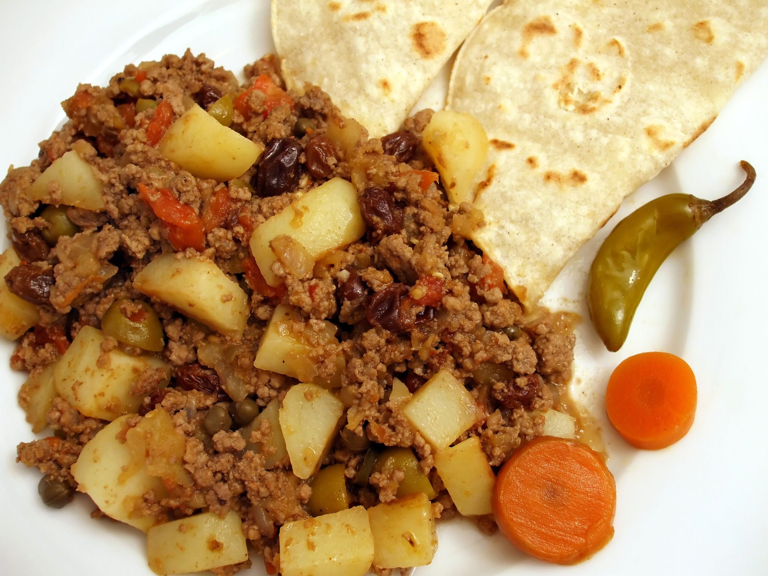 Picadillo on a White Plate With Soft Tortillas