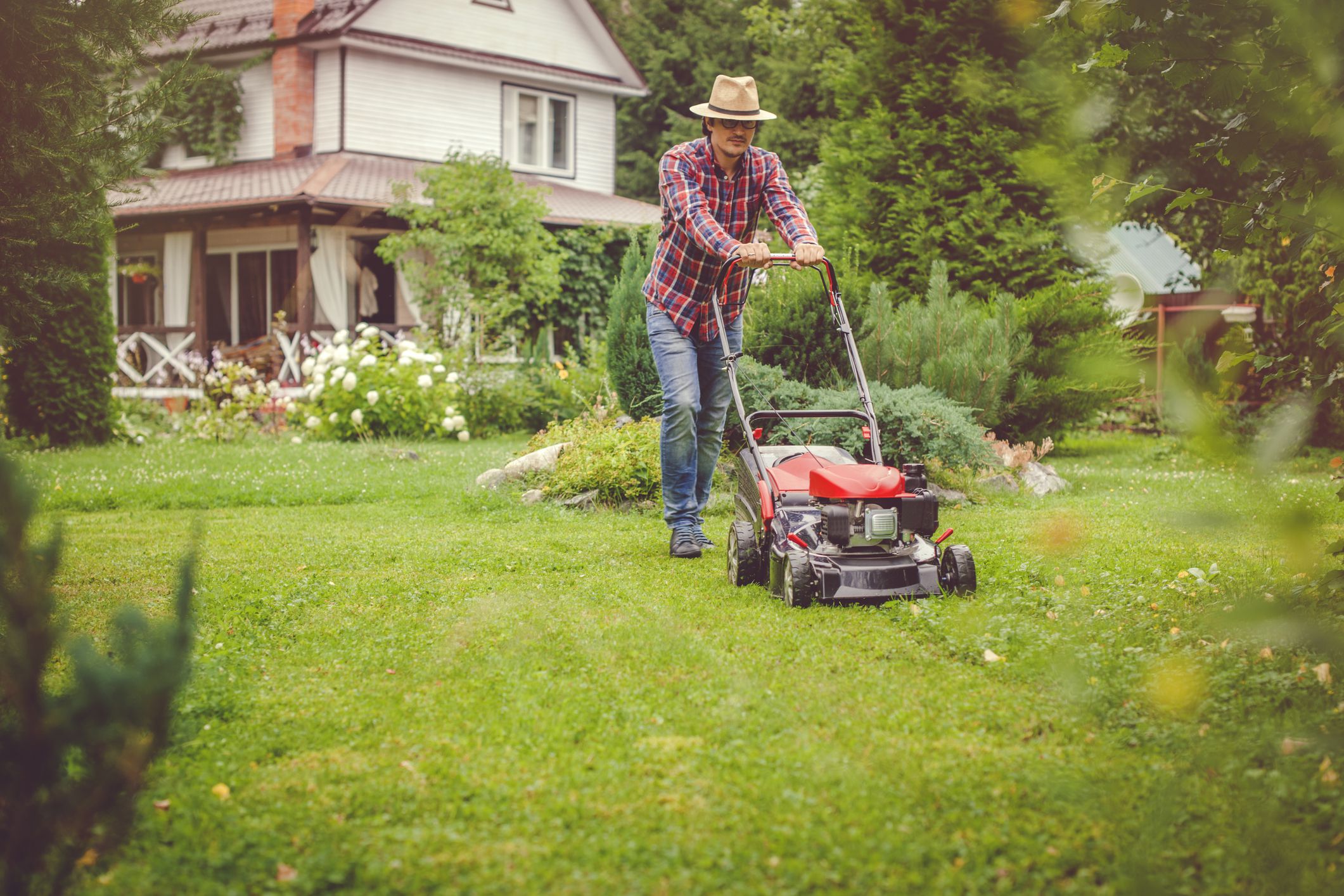 Man mowing grass near his house