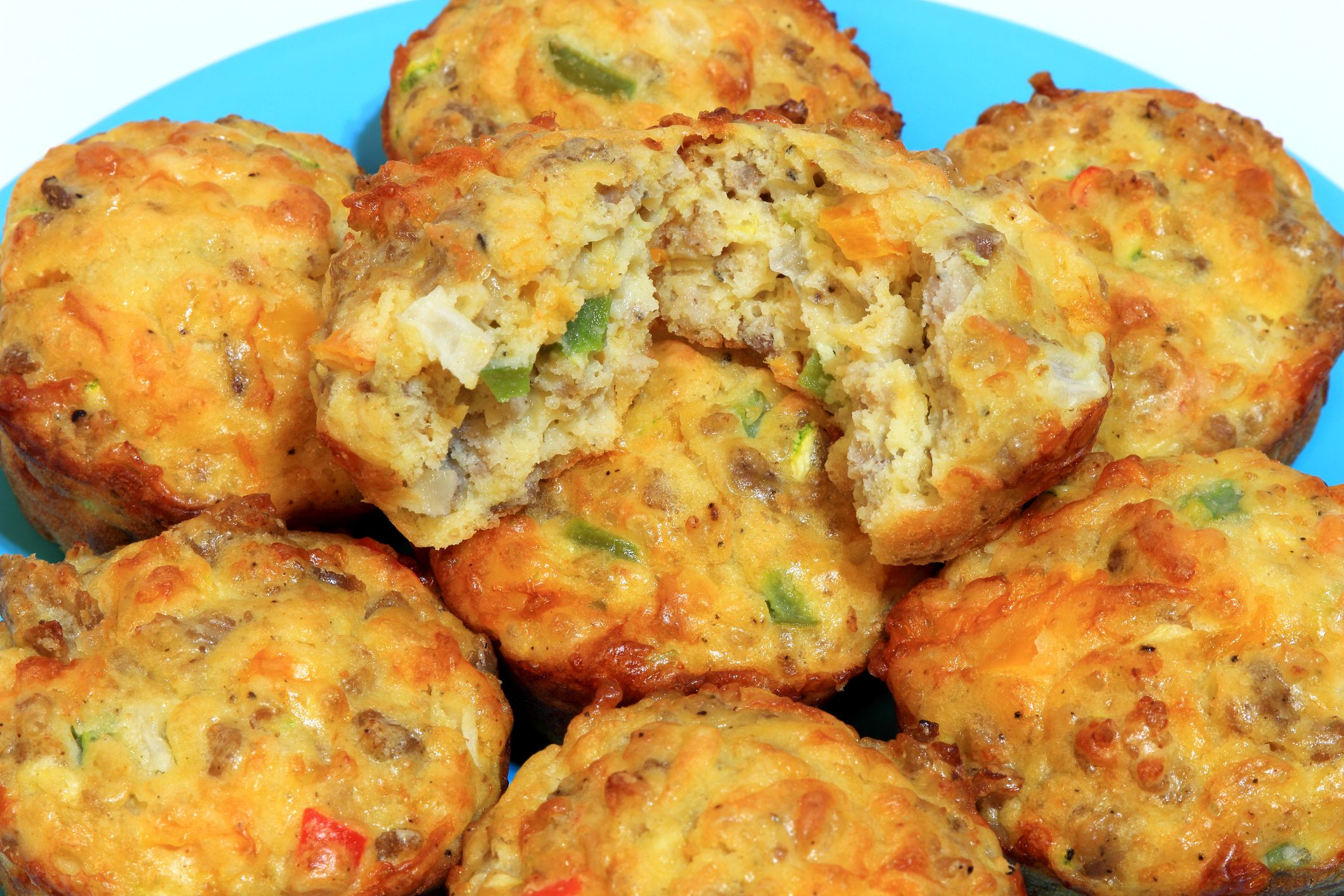 Breakfast muffins made with sausage, green & red bell peppers, shredded zucchini squash, cheese, and eggs.