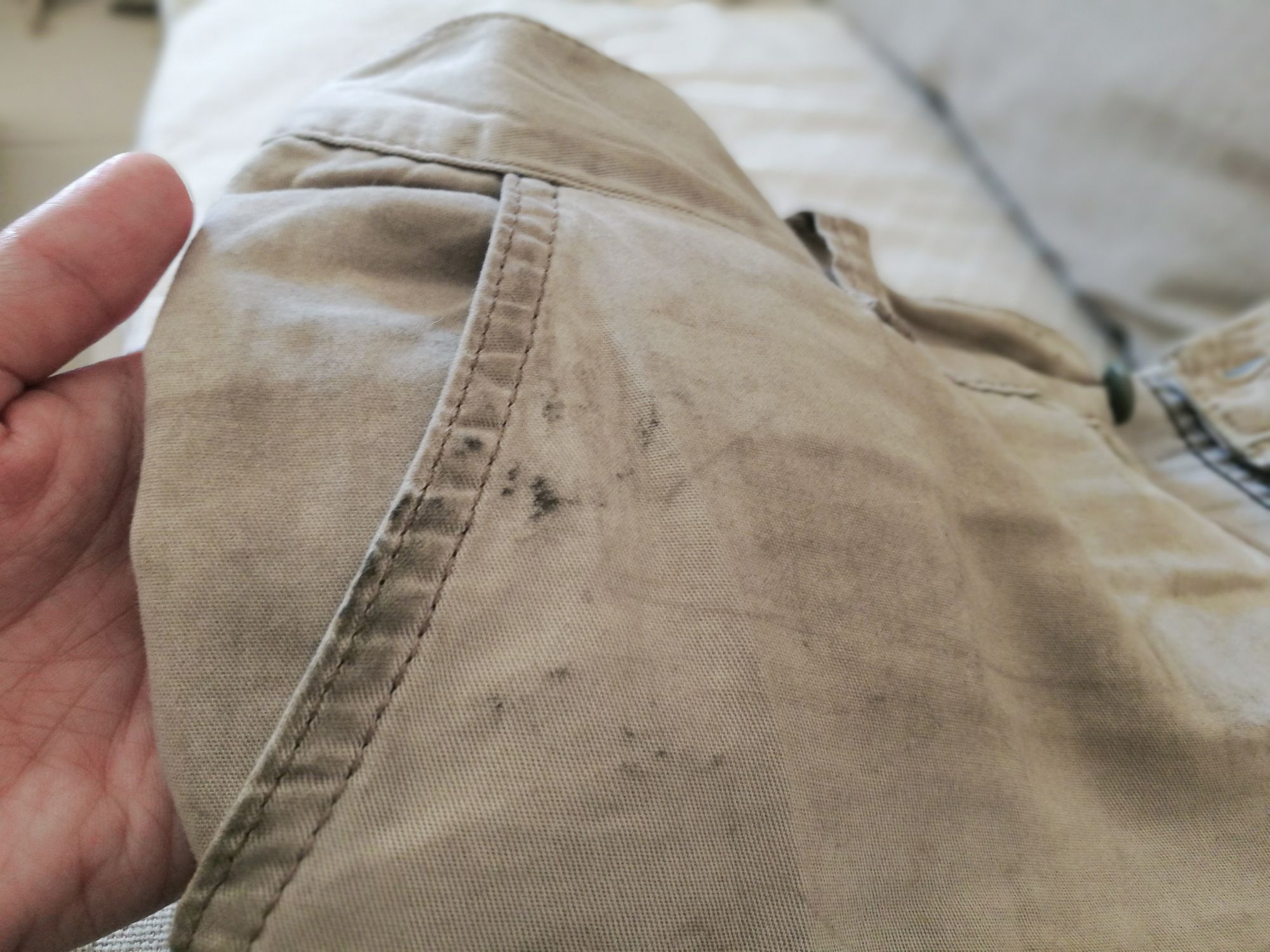Dirty trousers in hand. Oil stain or grease stain on clothes.
