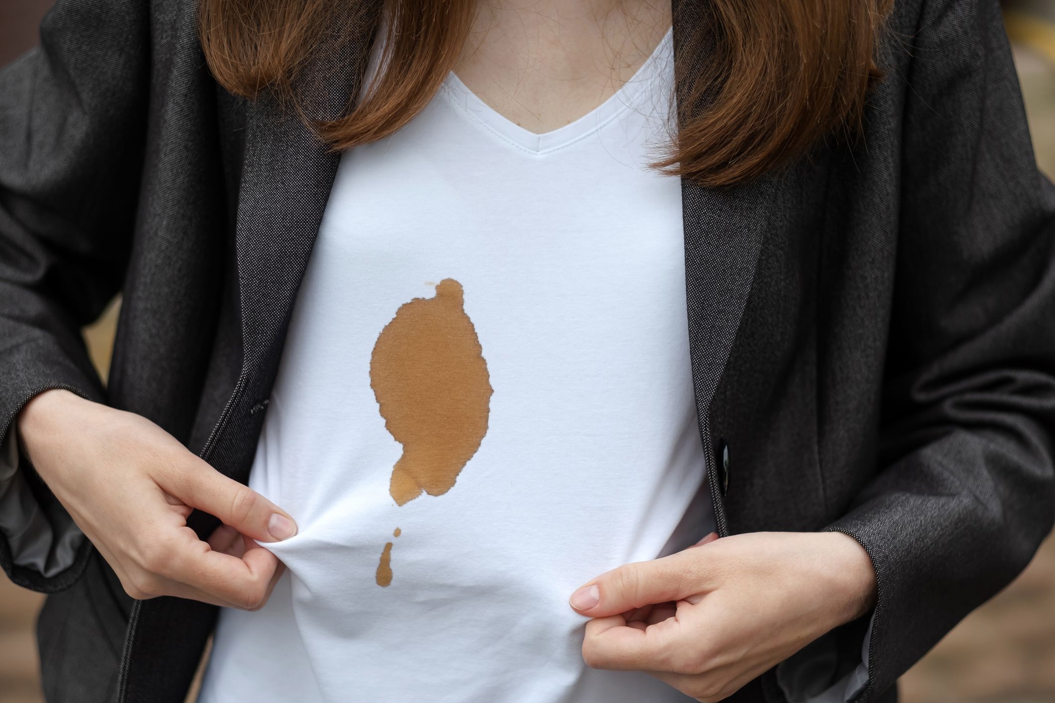 Female hands showing dirty stain of coffee. Outdoors