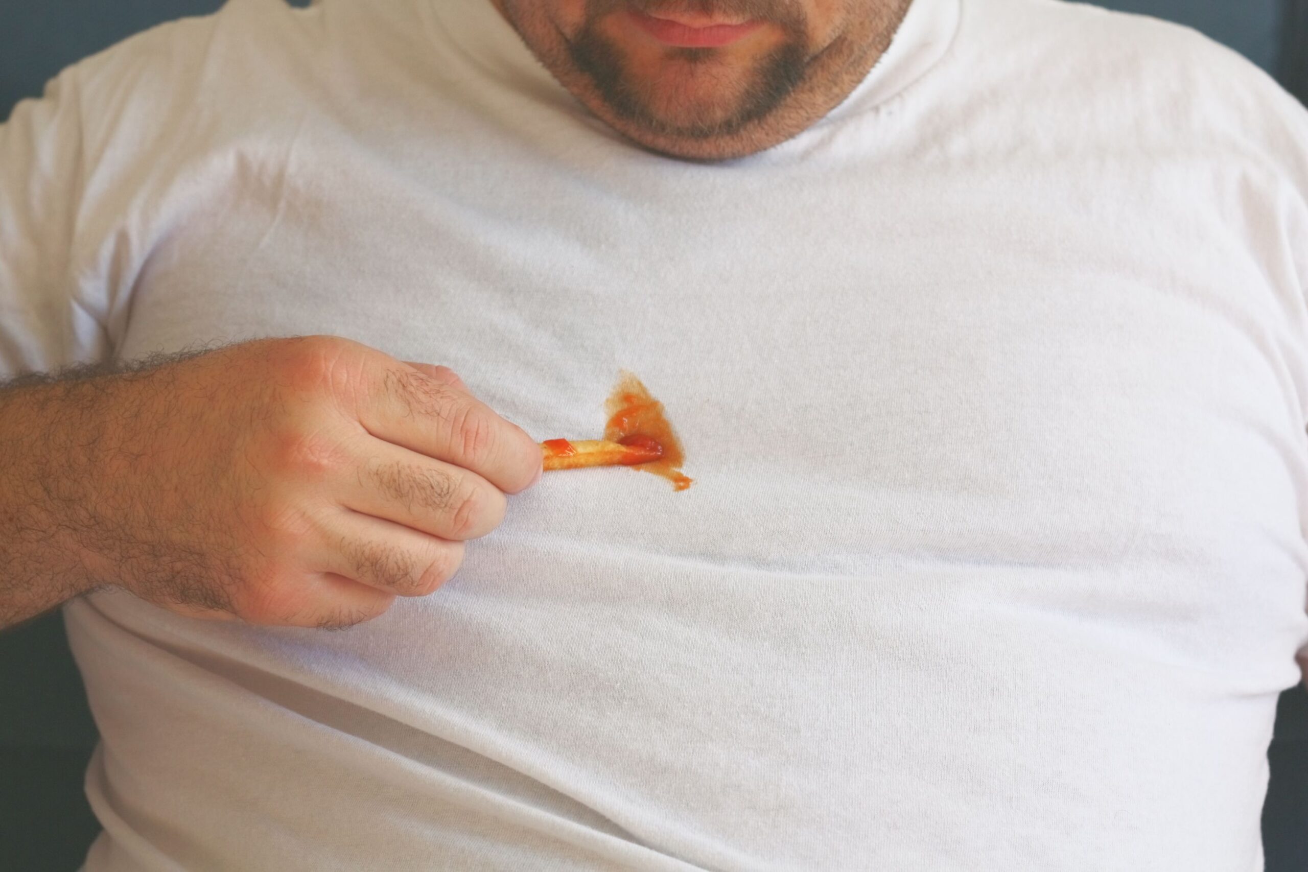 A man decides to try and clean his shirt by scraping off the ketchup with a french fry. Sometimes you have to do what you have to do!