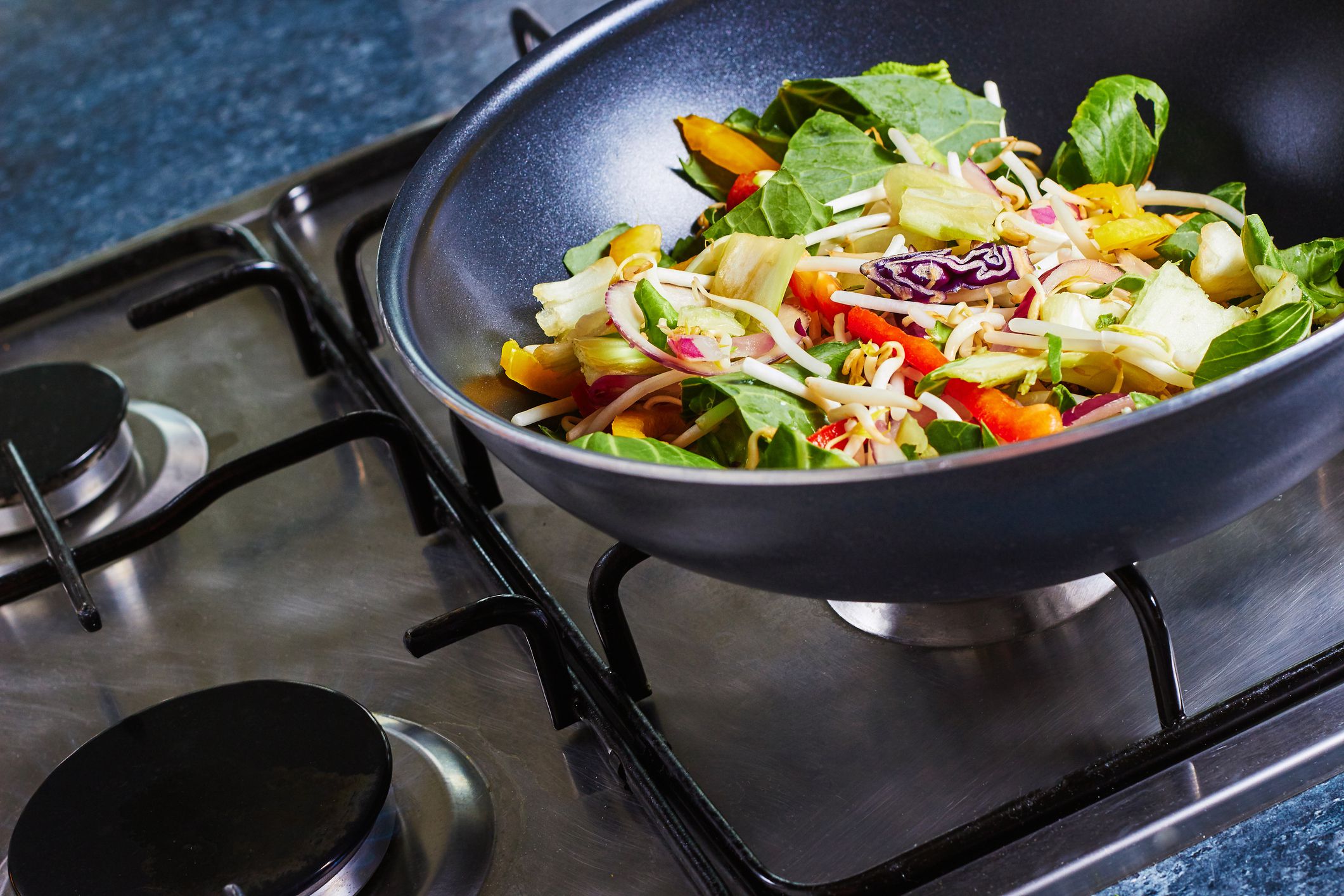 Stir fry vegetables in a wok, on a stove, cooking asian dish
