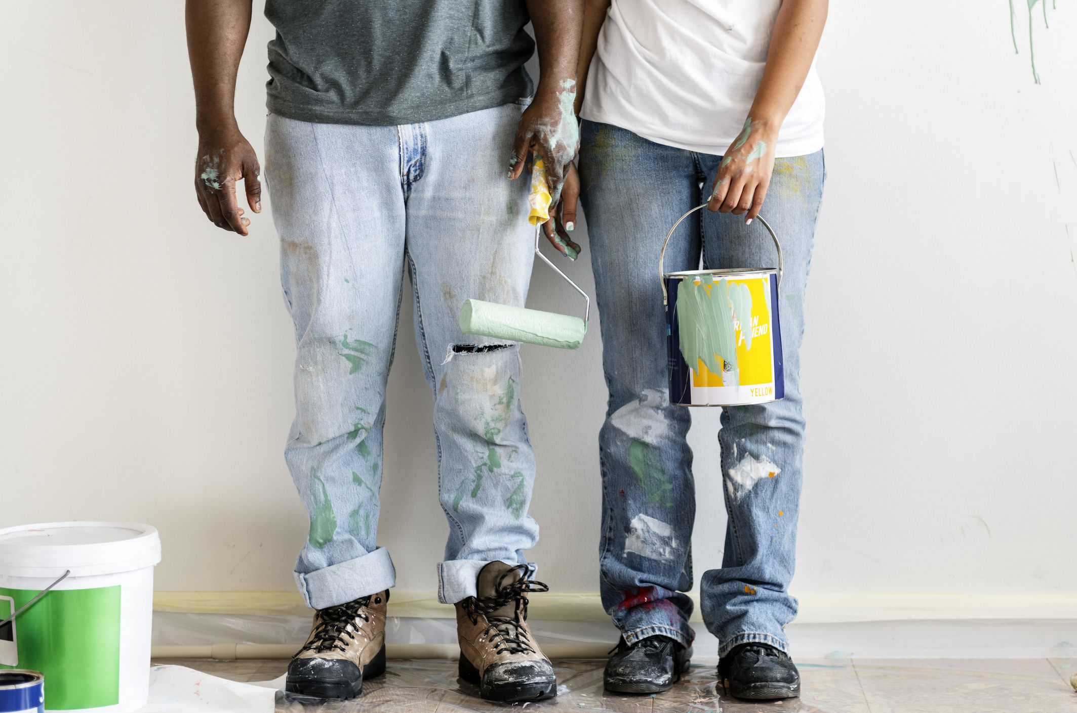 Couple painting house wall