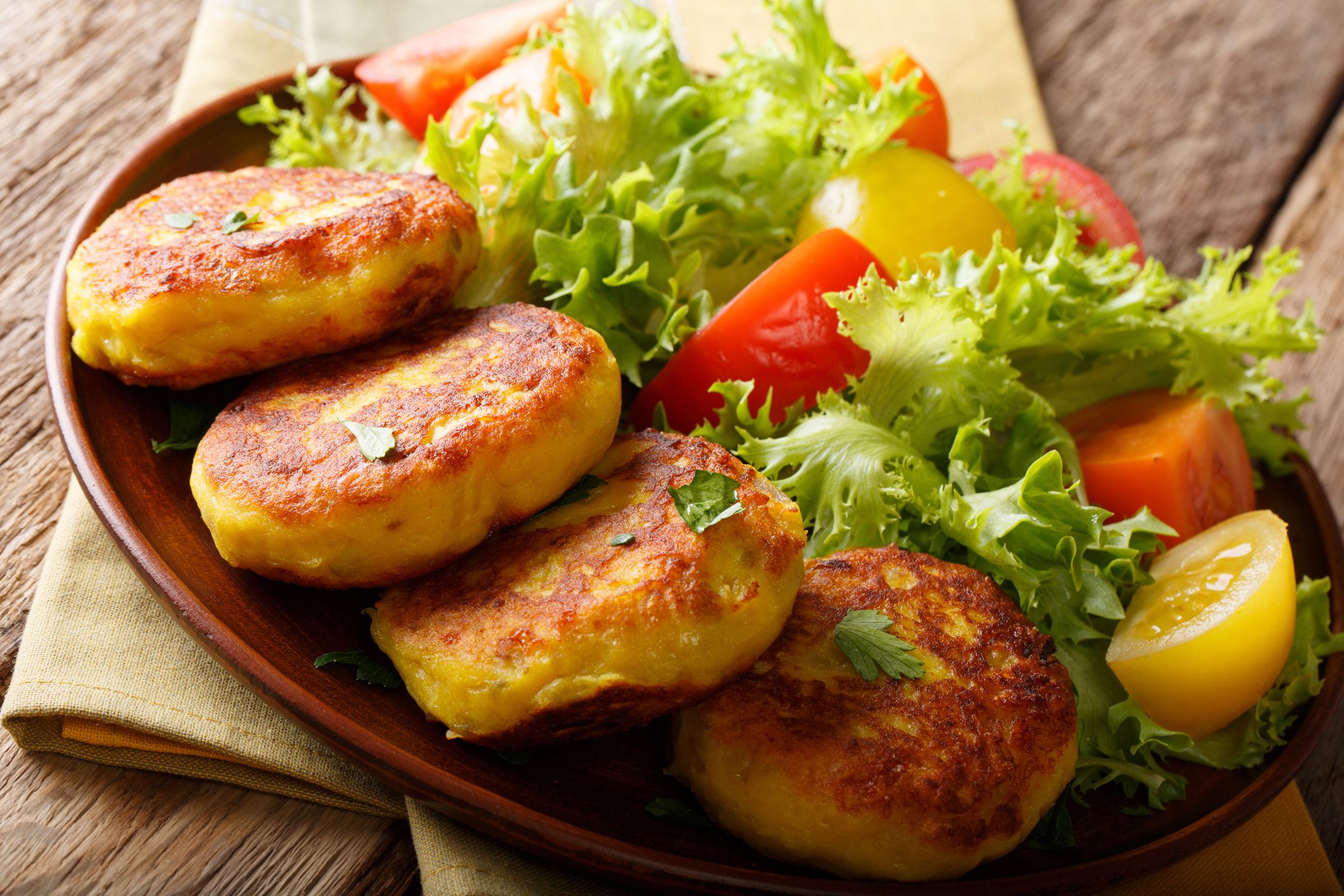 llapingachos With a Side Salad on a Brown Ceramic Plate