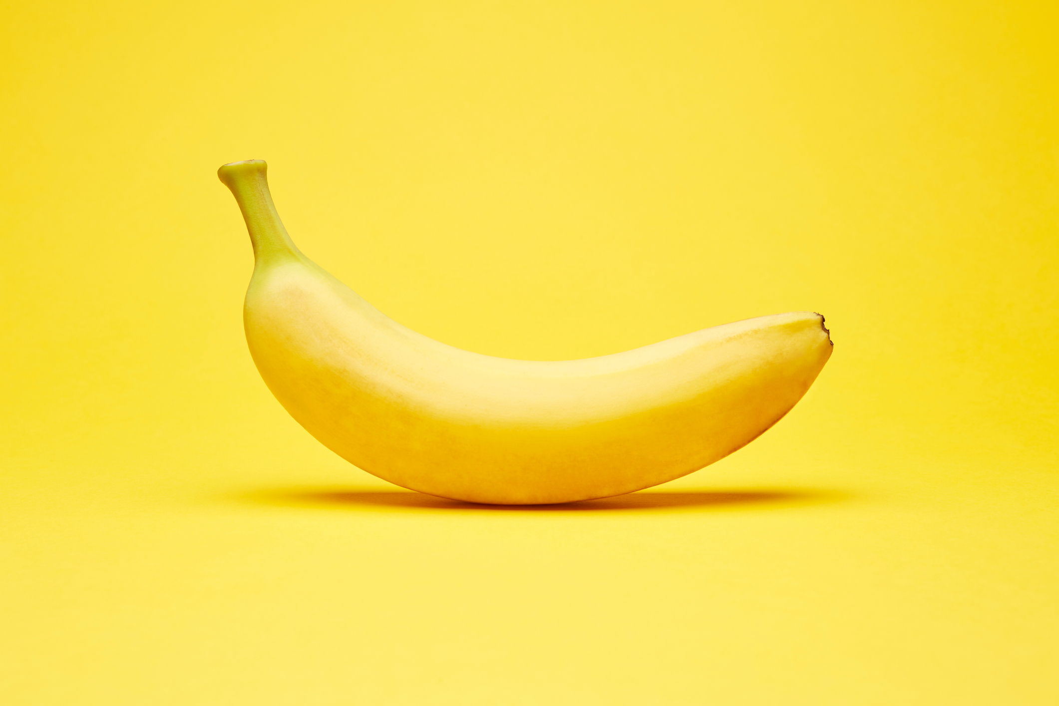 Single Banana on a Yellow Background