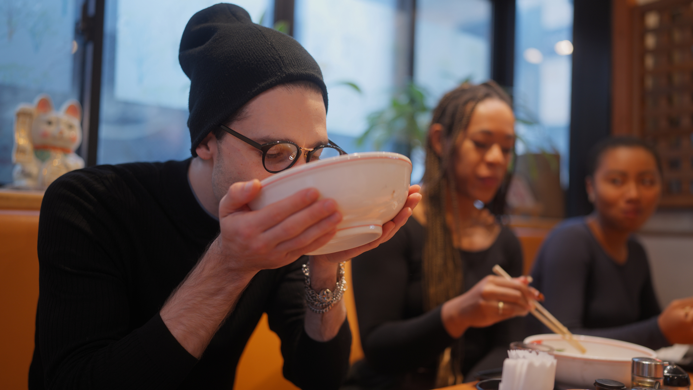 Man Drinking Ramen Bowl With Two Friends in a Ramen Restaurant in Japan