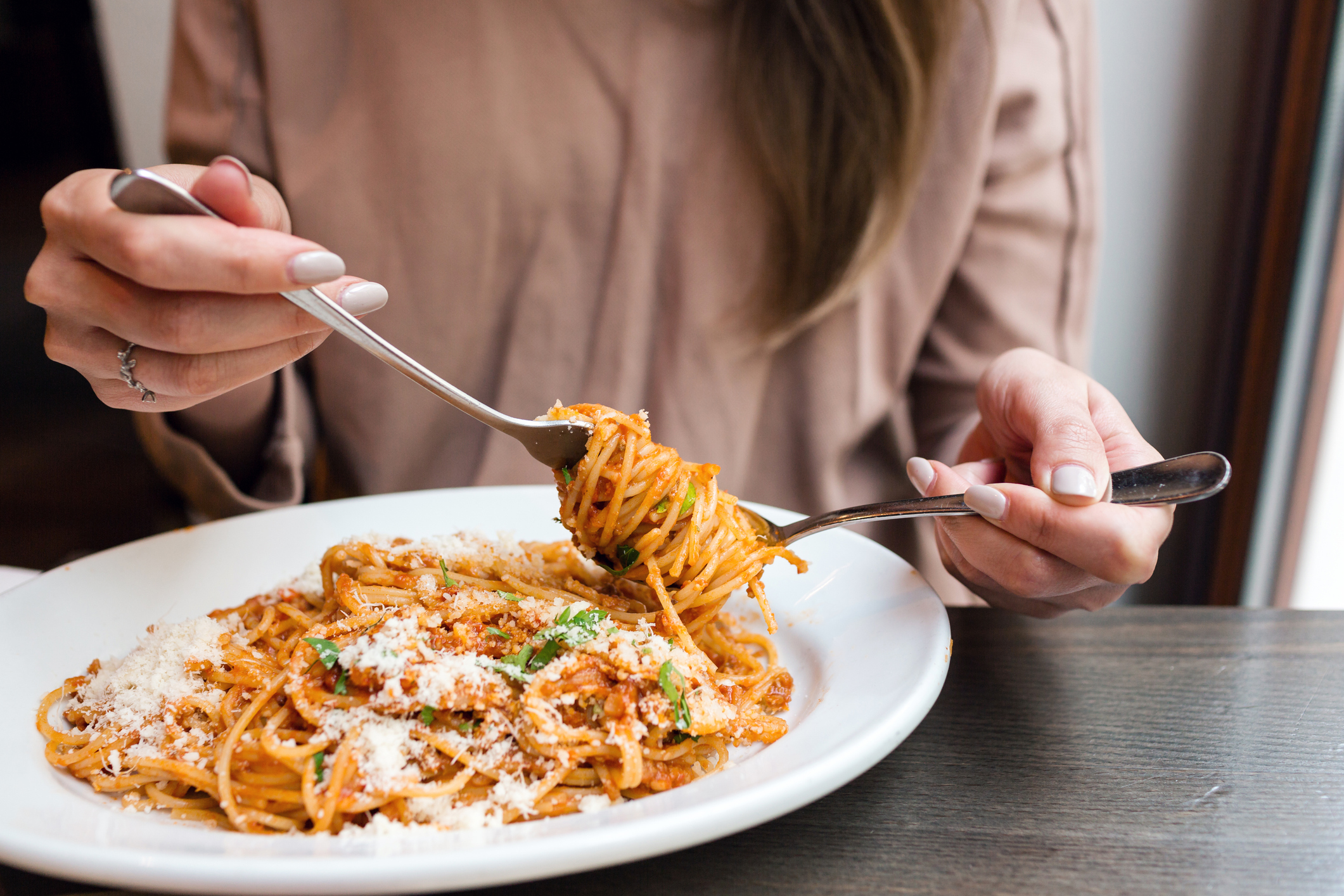 Woman Eating Spaghetti the Italian Way, Using a Fork and Spoon
