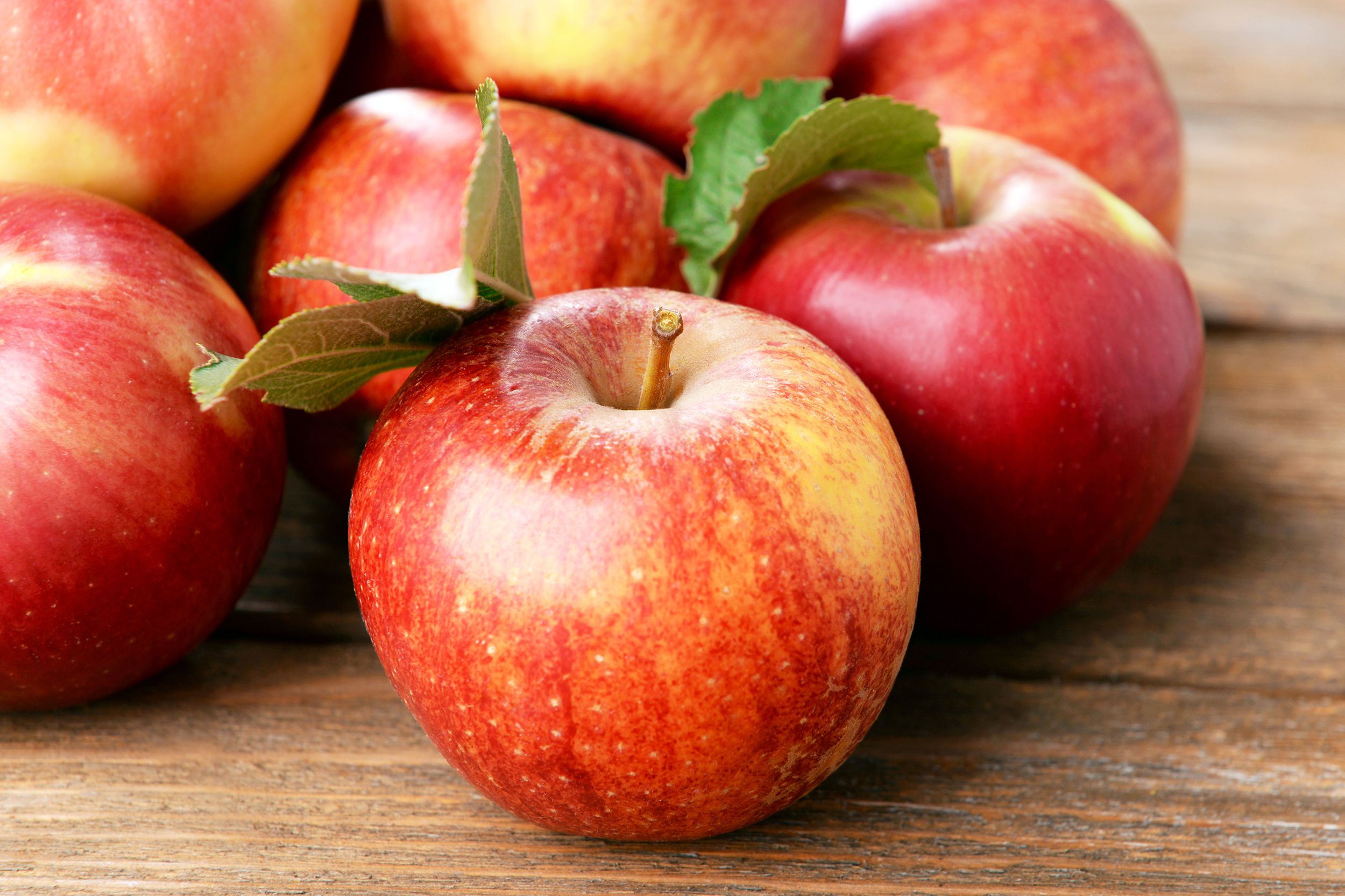 Ripe red apples on wooden background
