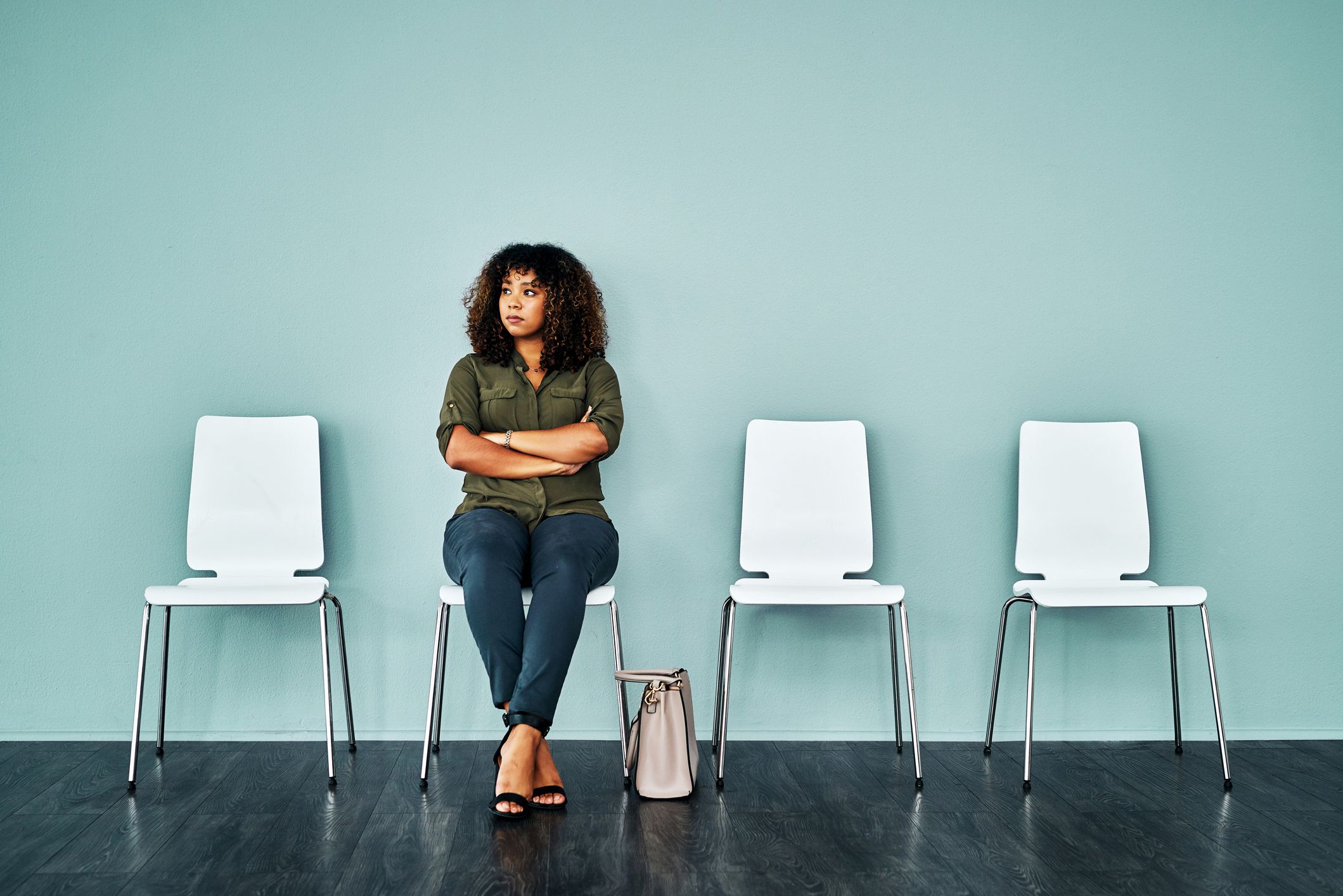 Studio shot of a young businesswoman waiting in line against a blue background