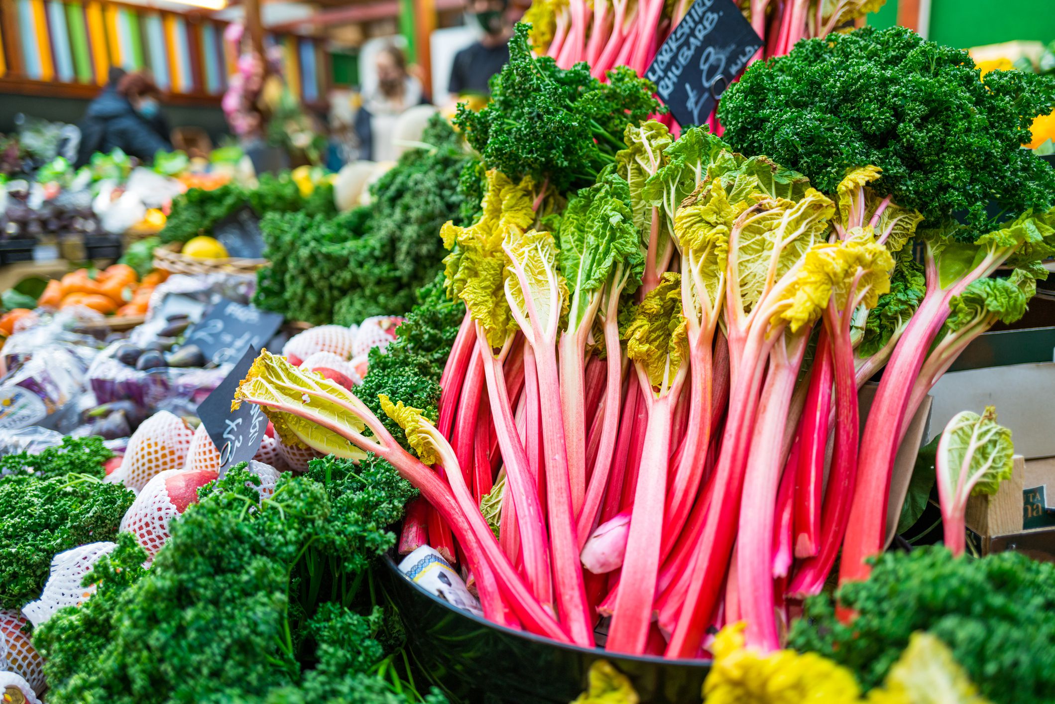 Sticks of fresh rhubarb for sale at a fruit and vegetable market.