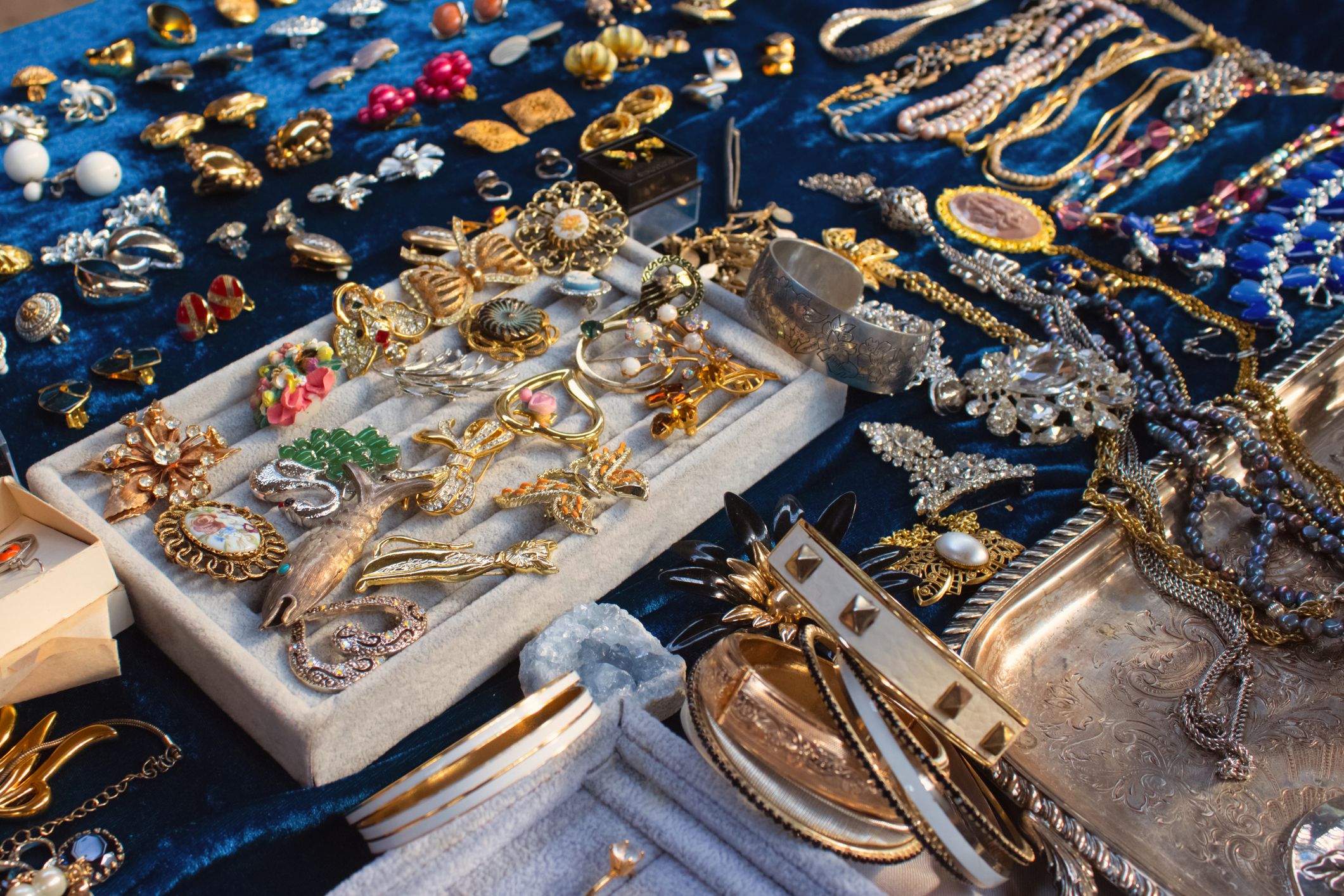 Antiques on flea market or seasonal festival - vintage jewelry, silver brooches and other vintage things. Collectibles memorabilia and garage sale concept, selective focus