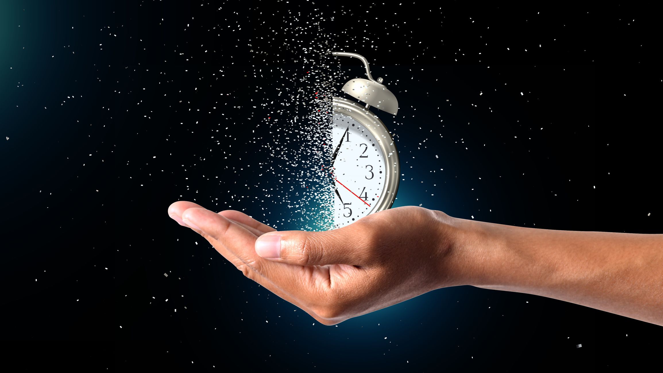 Concept of passing away, the clock breaks down into pieces. Hand holding analog clock with dispersion effect