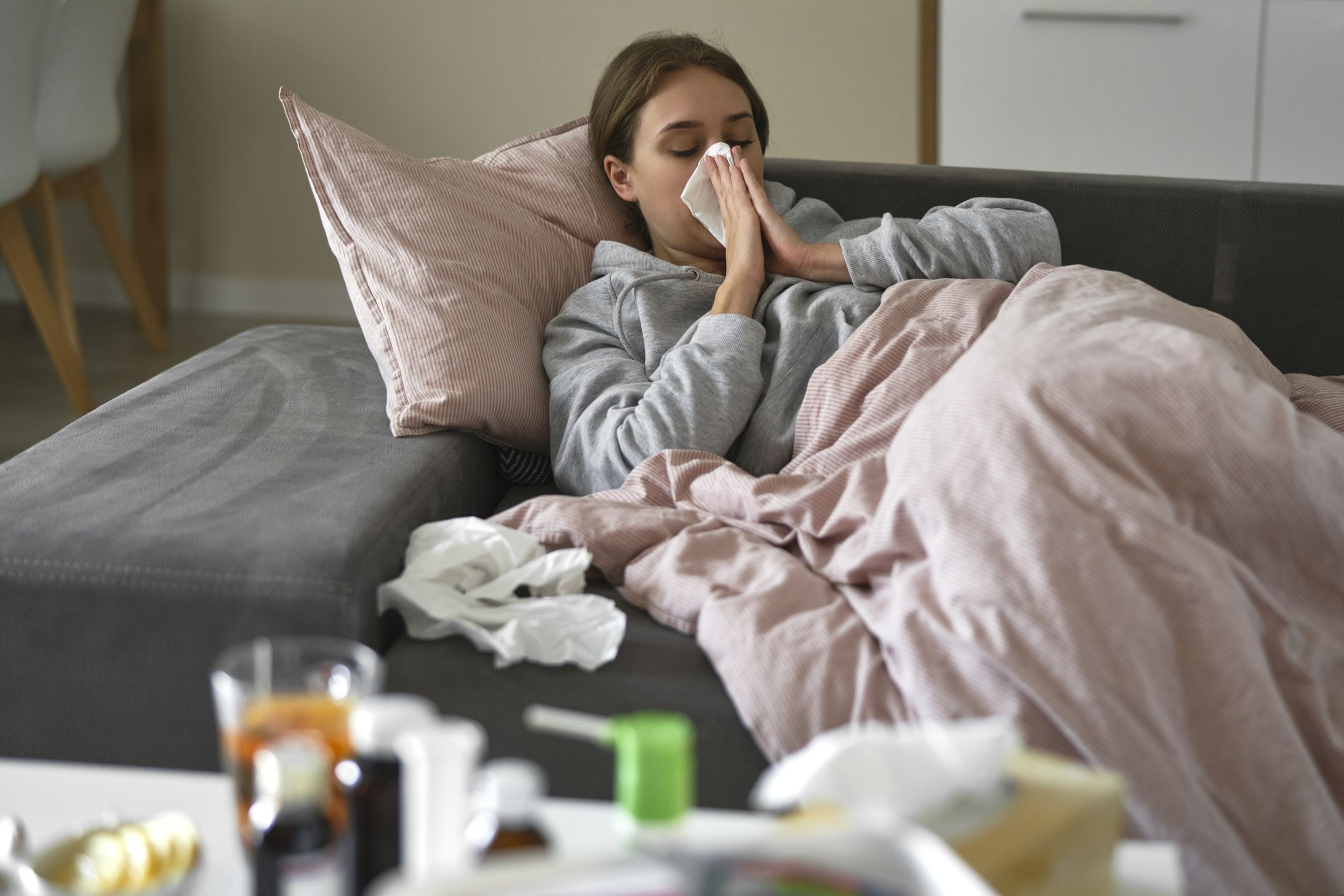 Caucasian woman lying on sofa with flu at home
