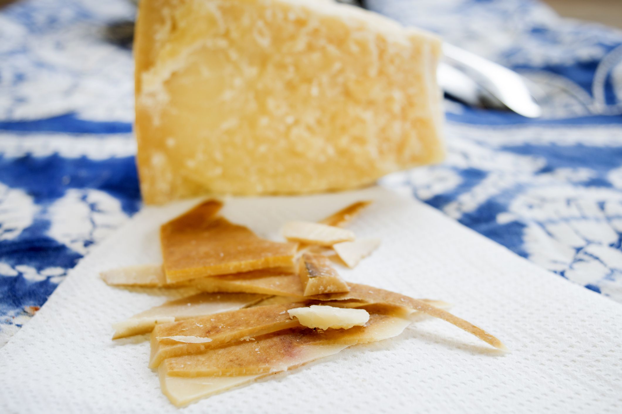 chunks and rind of parmigiano cheese with near a big piece of heart