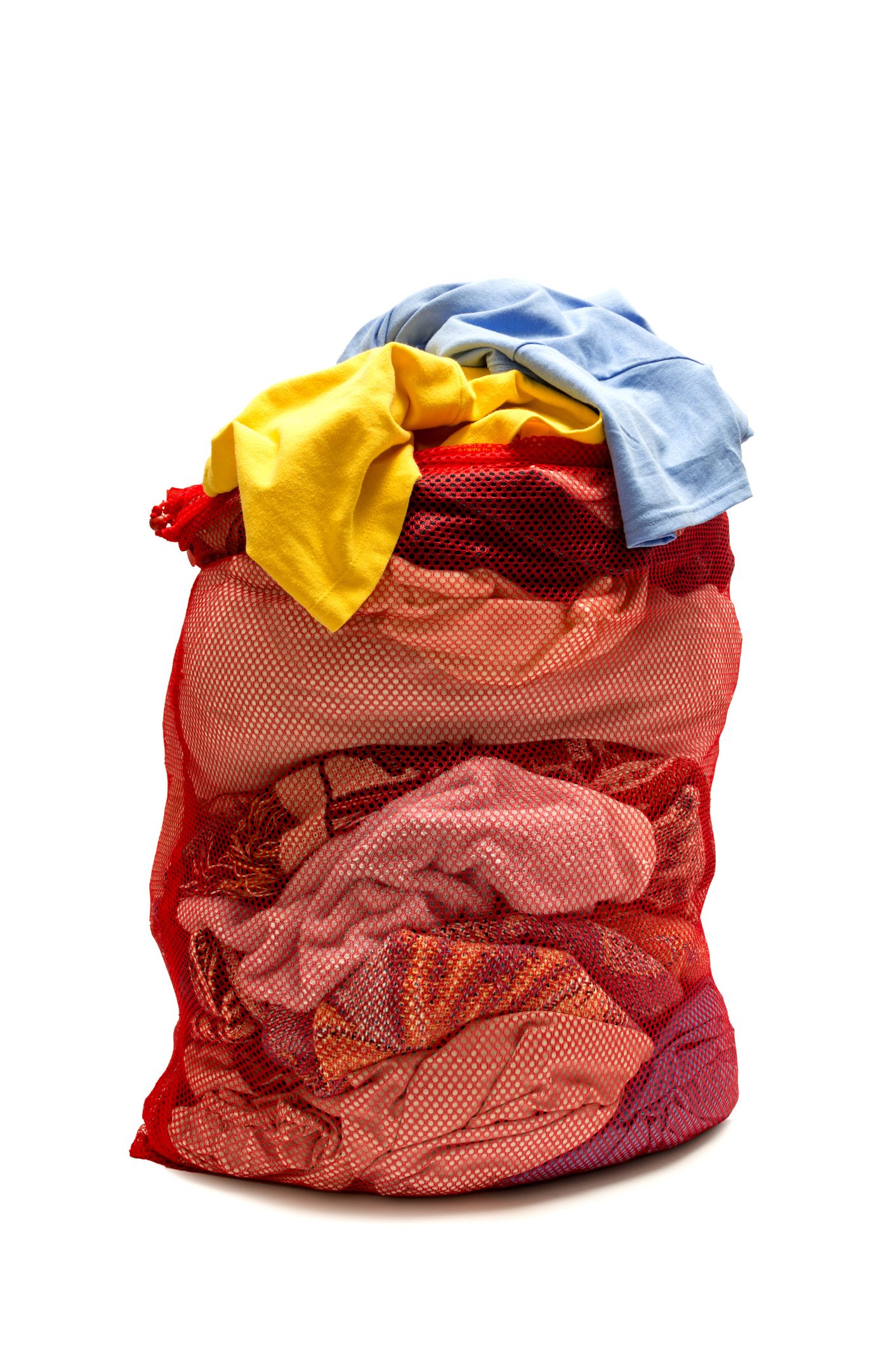 Vertical shot of a red mesh laundry bag overstuffed with laundry. On white background