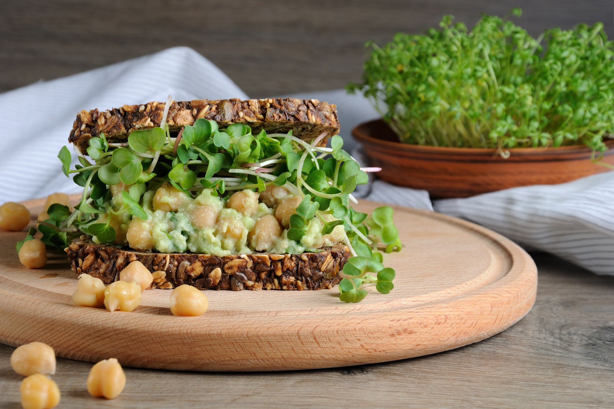 Sandwich of rye bread with cereals with crushed avocado, chickpeas and sprouts of radish shoots.A great idea for those who watch their health and vegetarian.