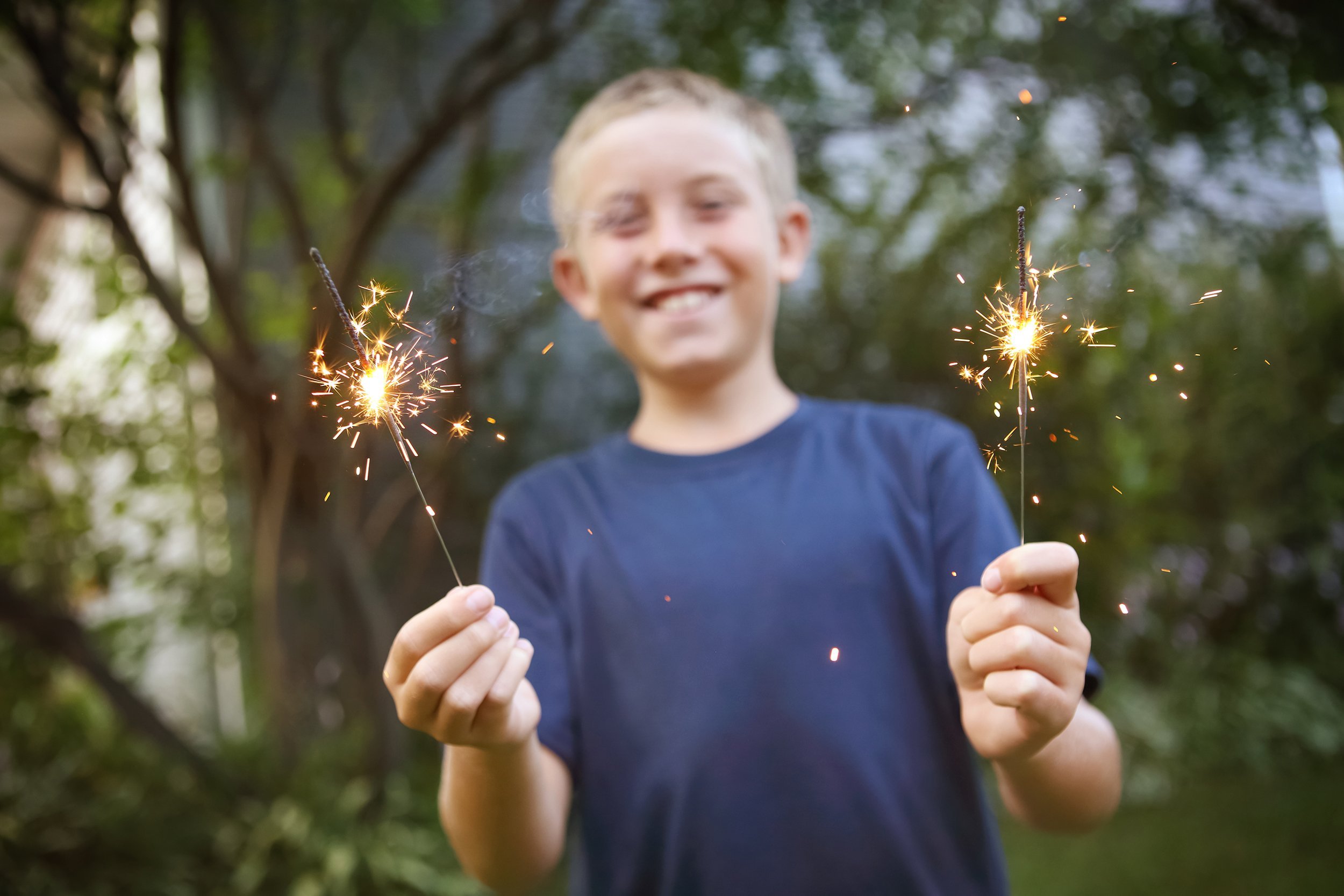 smiling boy holding sparklers