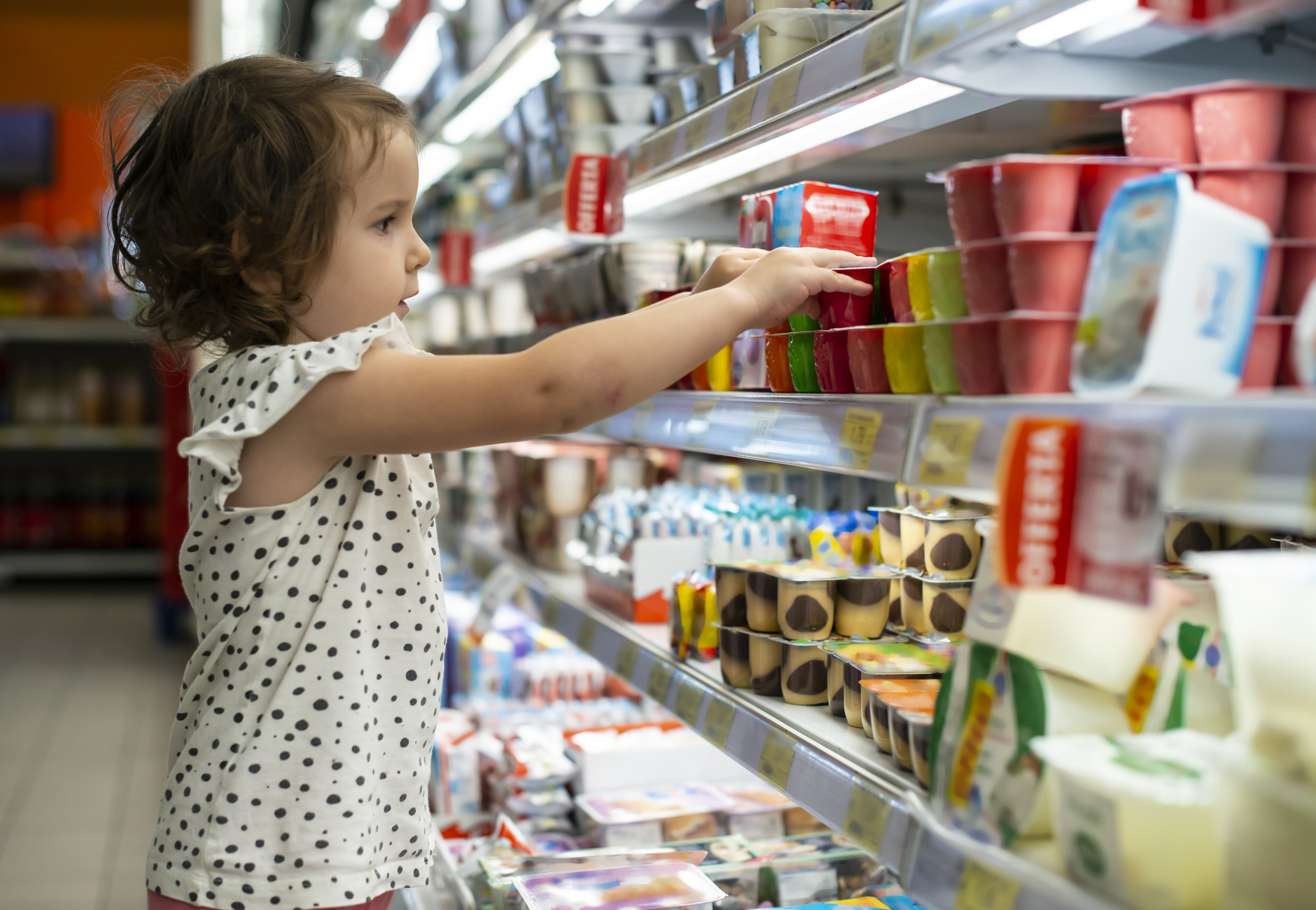 Little Girl Grabbing Yogurt in a Grocery Store