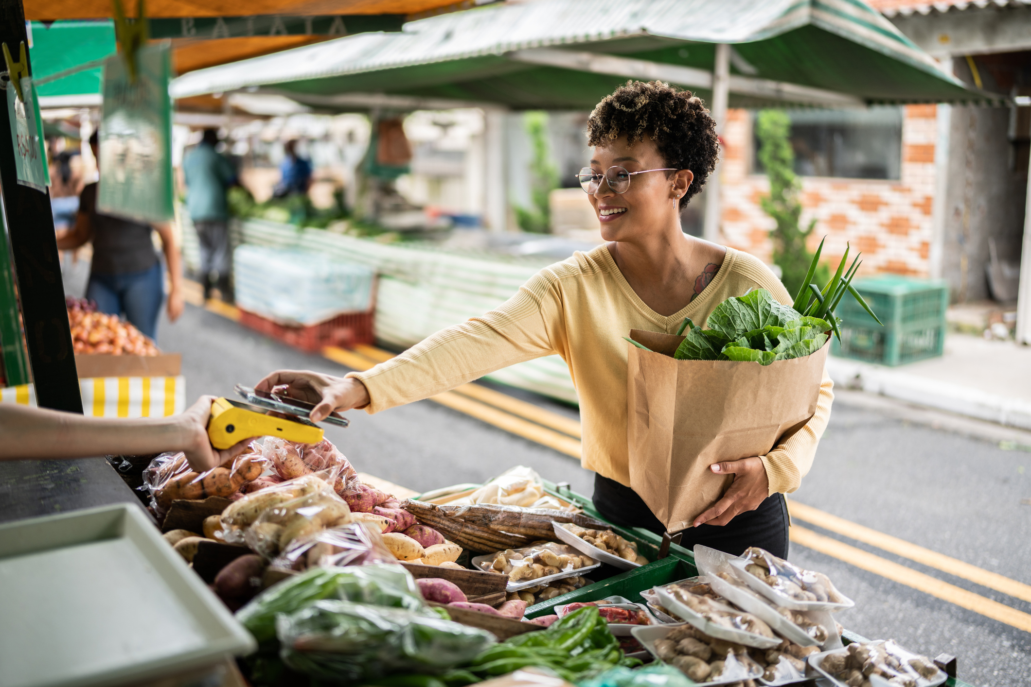 Woman Paying With Her Smartphone at a Stall in a Farmer's Market