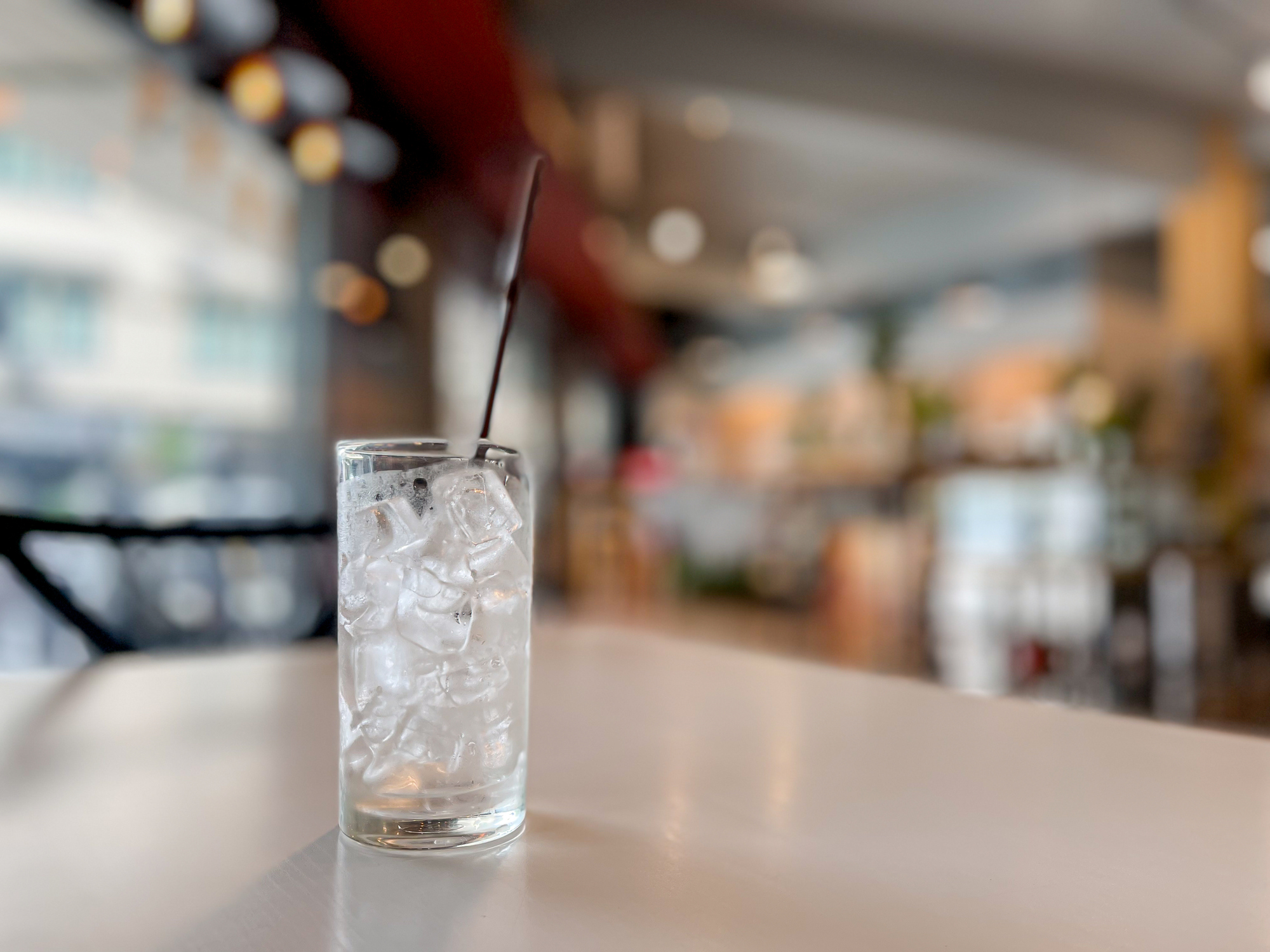 Glass of Water With Lots of Ice With a Straw on a Table in a Restaurant