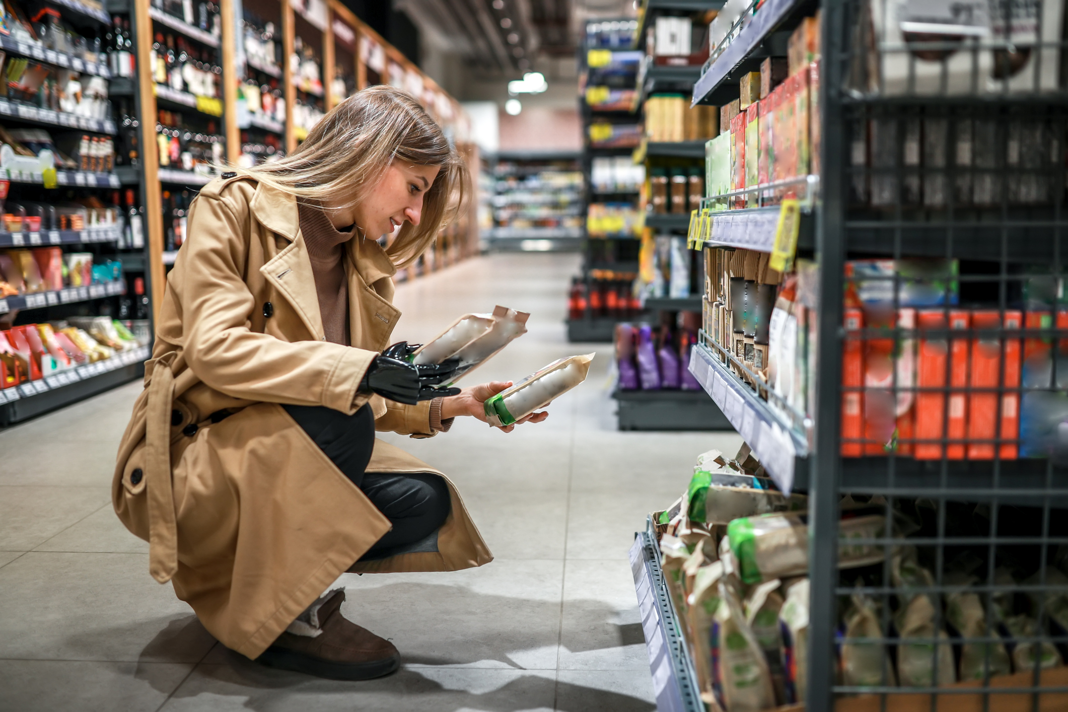 Woman Kneeled Selecting Items from Bottom Shelf in a Grocery Store