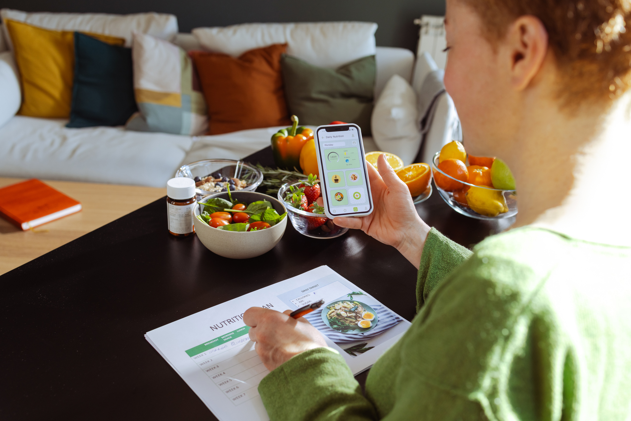 Woman Is Making a Weekly Nutrition Plan and Using a Mobile App in Her Living Room