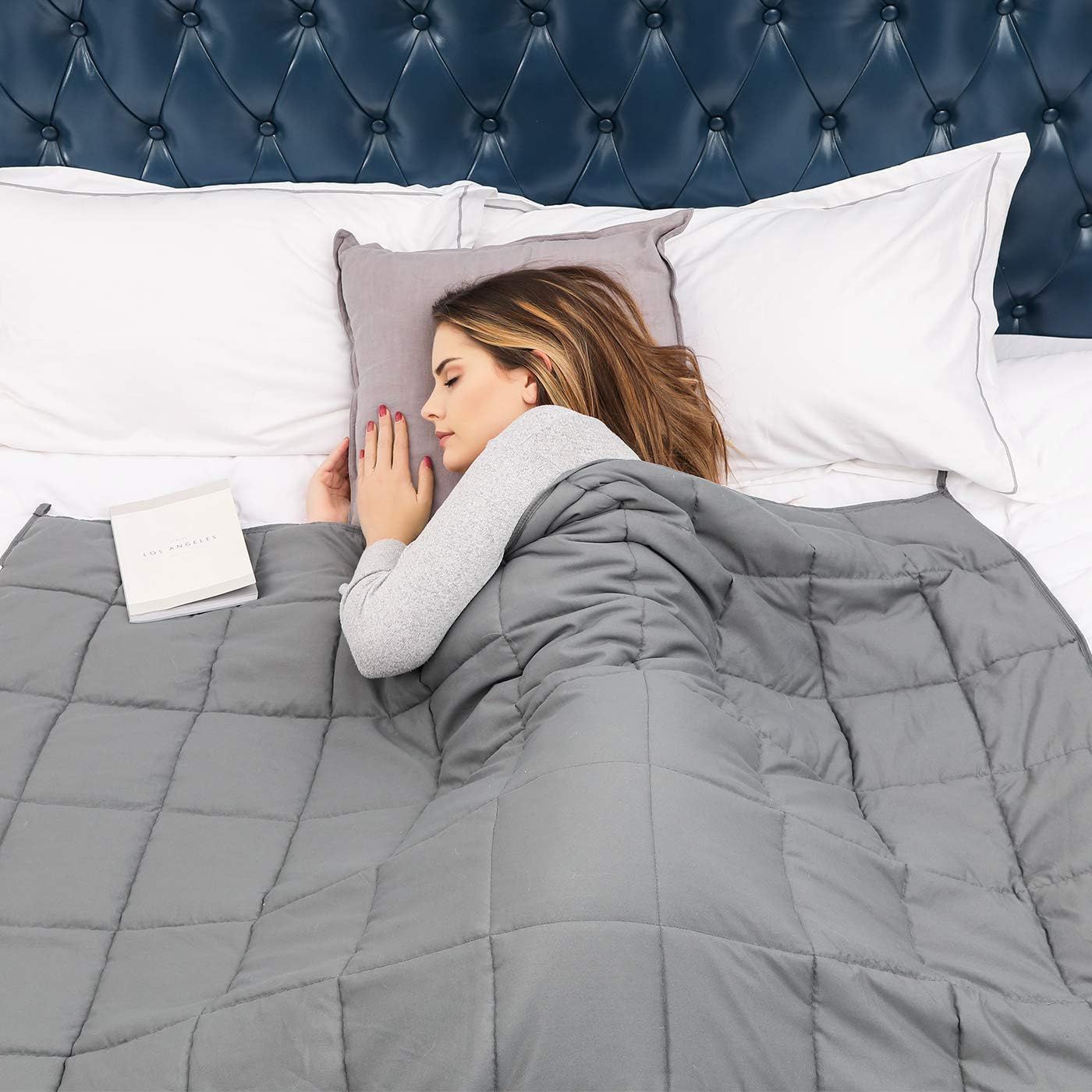 a woman in bed with a weighted blanket