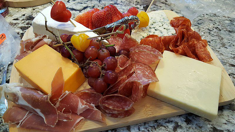 A charcuterie board with cheese and fruit