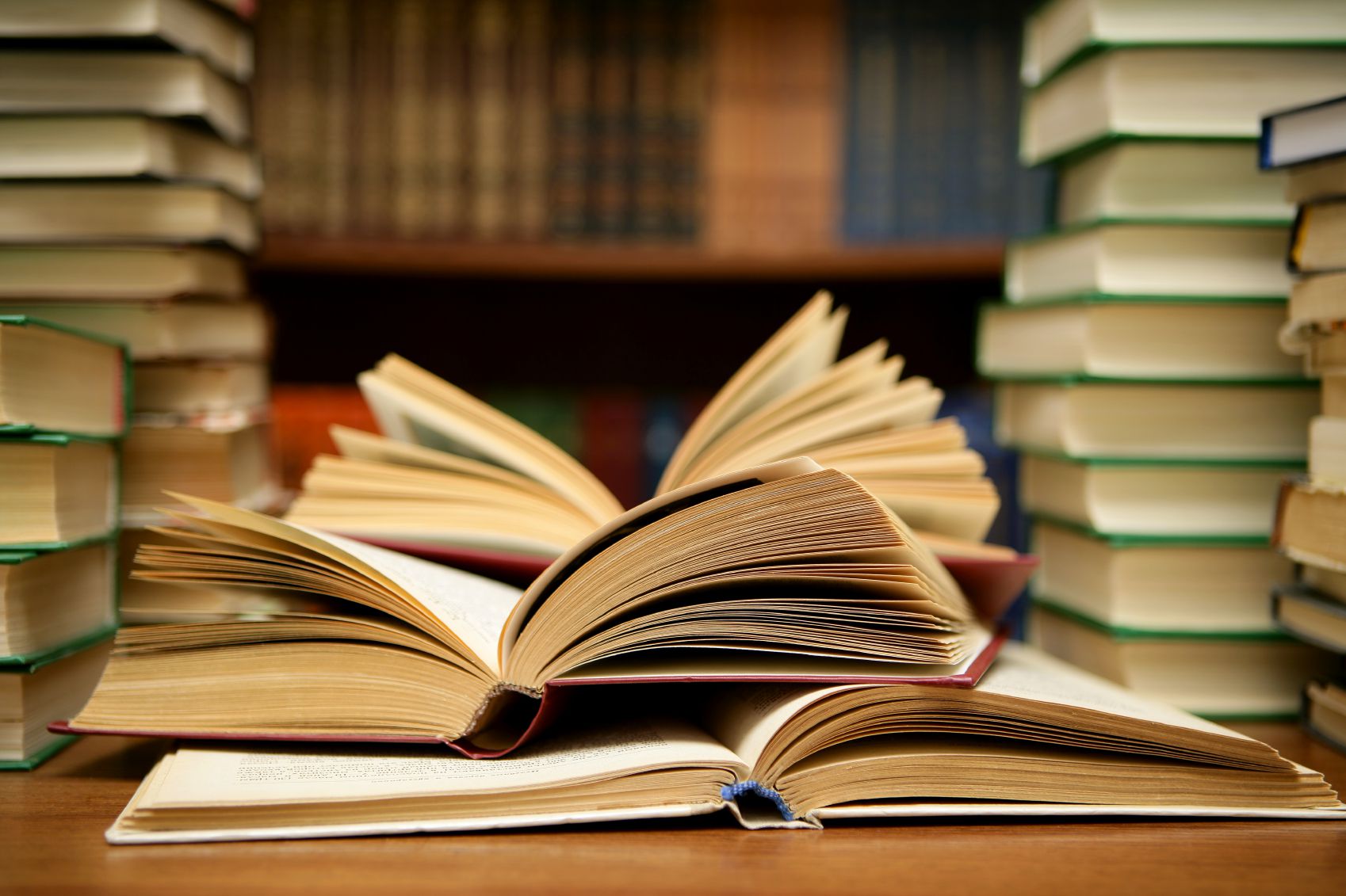 Several books, a few of them are opened on a desk