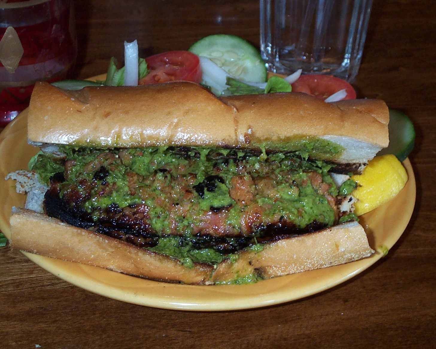 Choripán sandwich with green chimichurri sauce