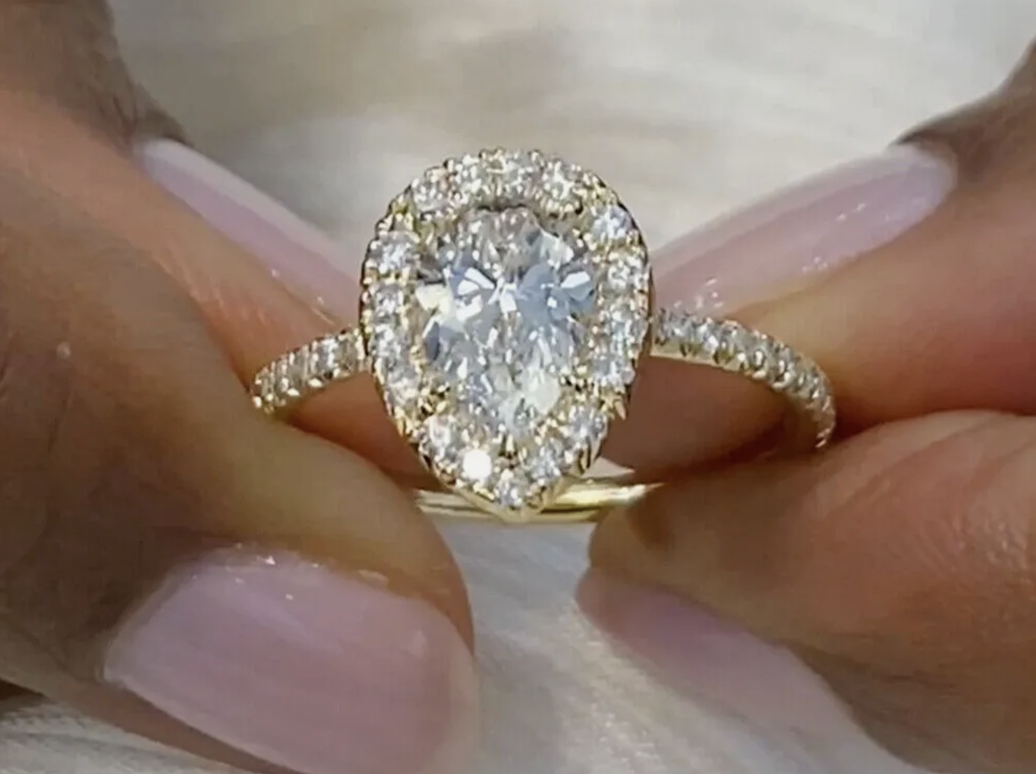Diamond engagement right held with a woman who has pink nail polish