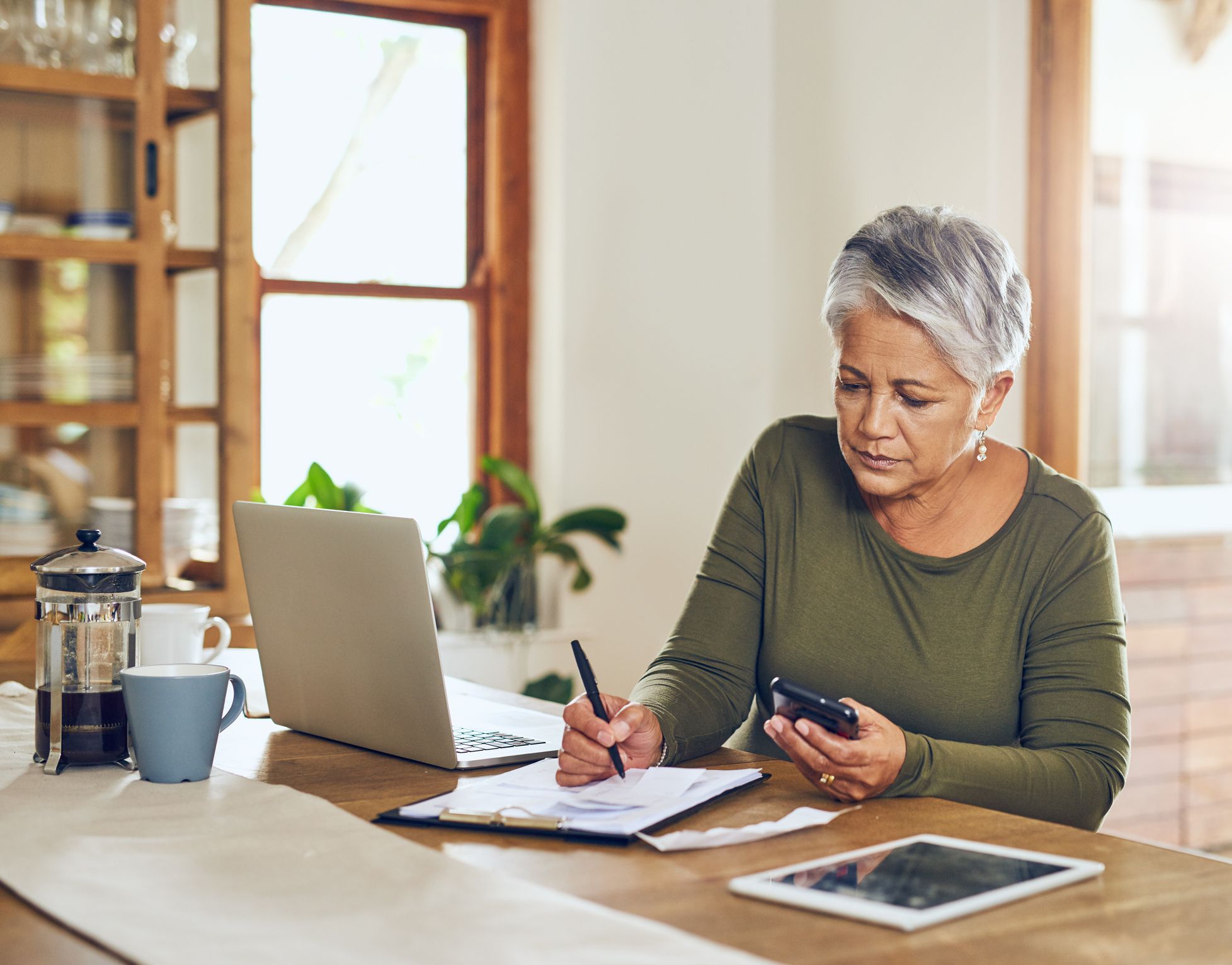 Shot of a mature woman going through paperwork at home