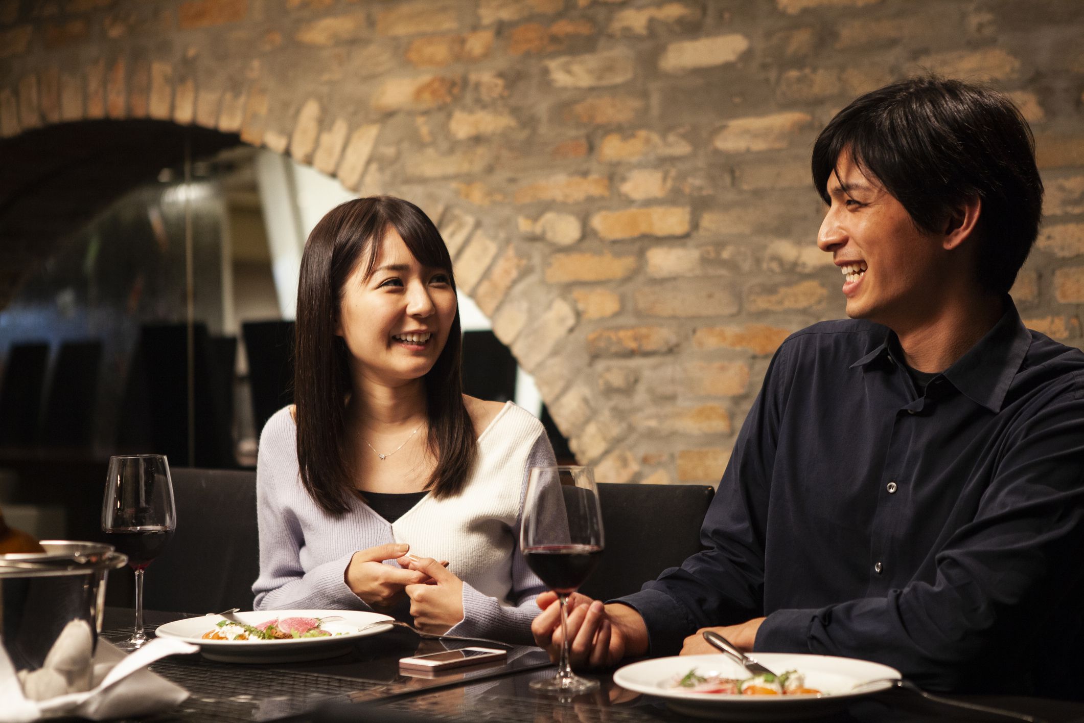 In a restaurant a women is eating dinner.