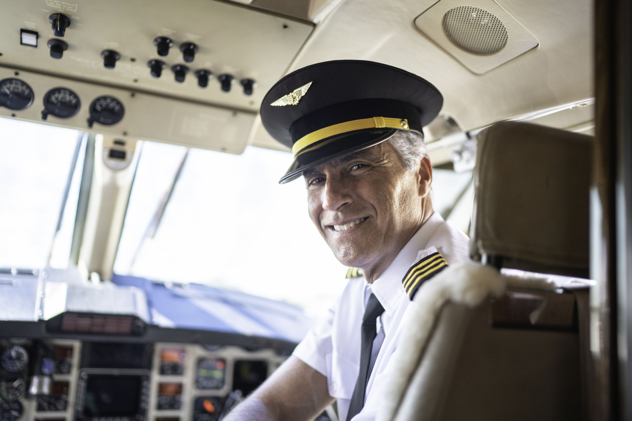 Portrait of airplane pilot looking over shoulder in a private jet