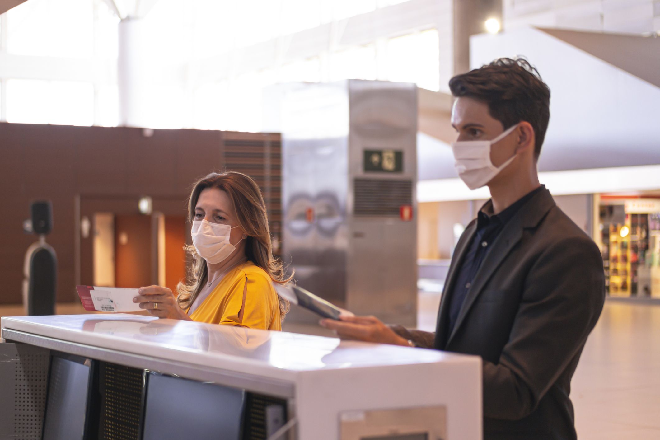 Photo of businessman and woman at an airport making check in.